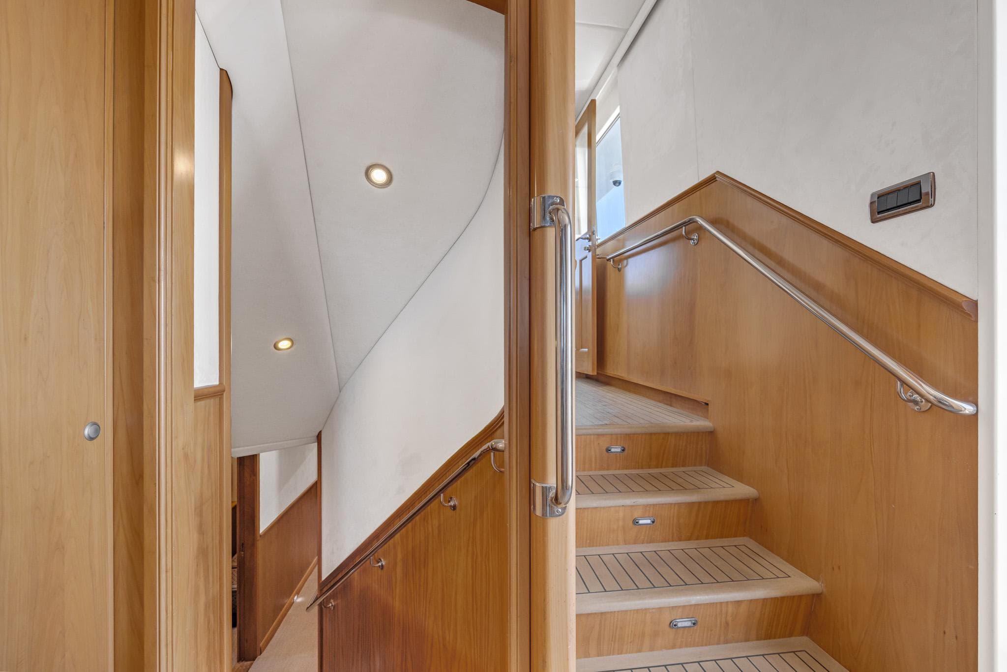 Interior staircase of 2007 Custom 86' Carey Shipyard yacht with wooden finish and modern design.