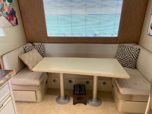 Cozy dining nook in 1990 Viking Extended Aft Deck Motor Yacht with cushioned seating and table.