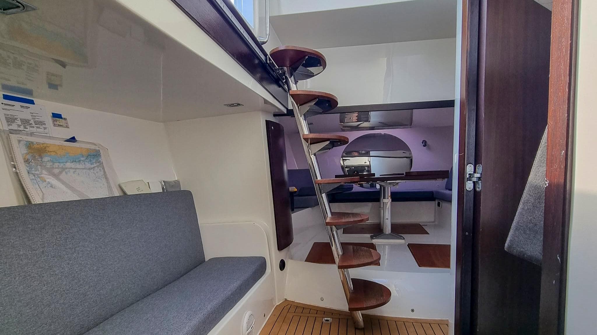 Interior of 2008 Custom Cantieri Opera 60 yacht with spiral staircase and seating area.