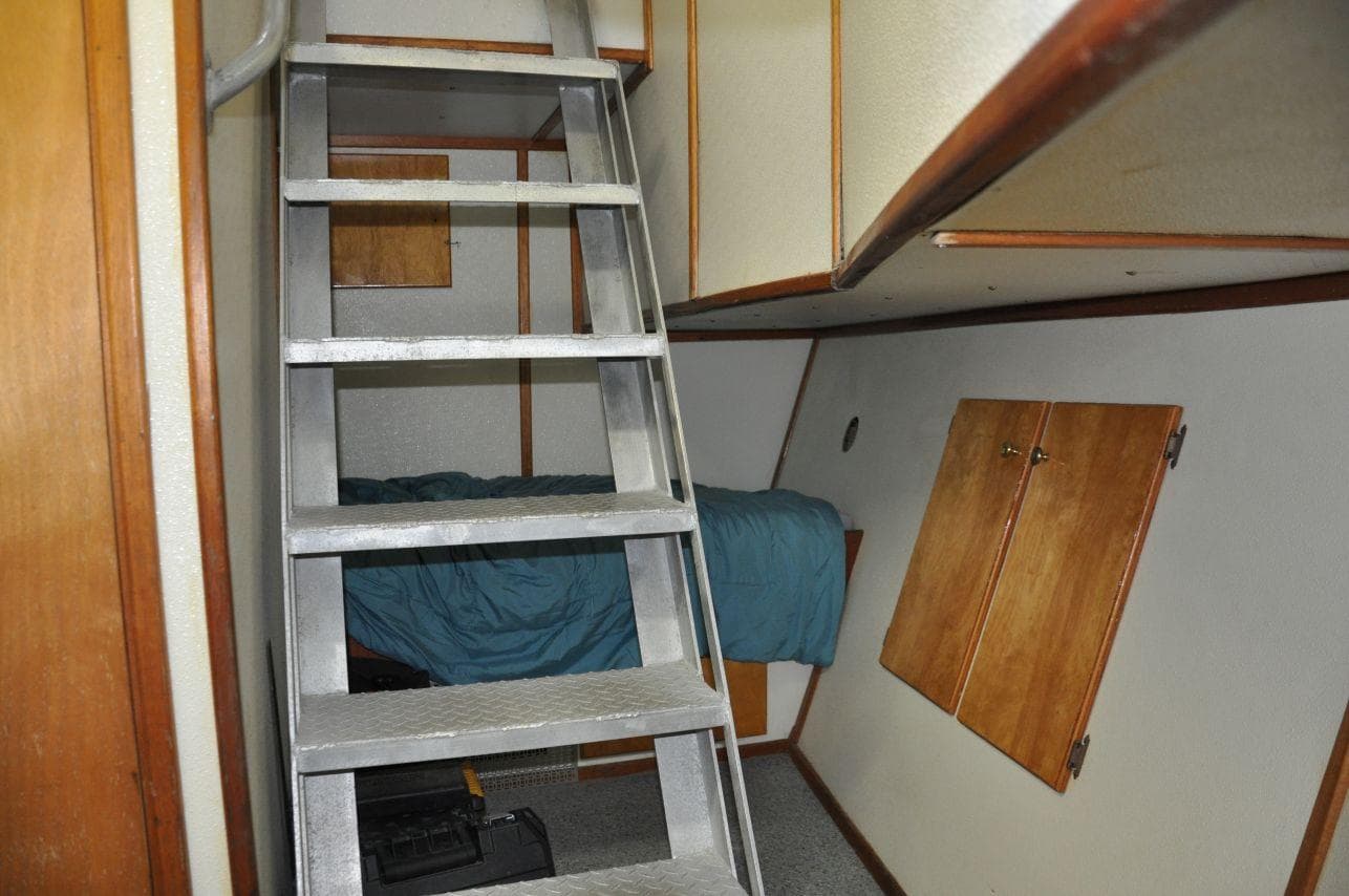 Interior of 1999 Rodriquez 50 Pilothouse with ladder, bed, and wooden cabinets.