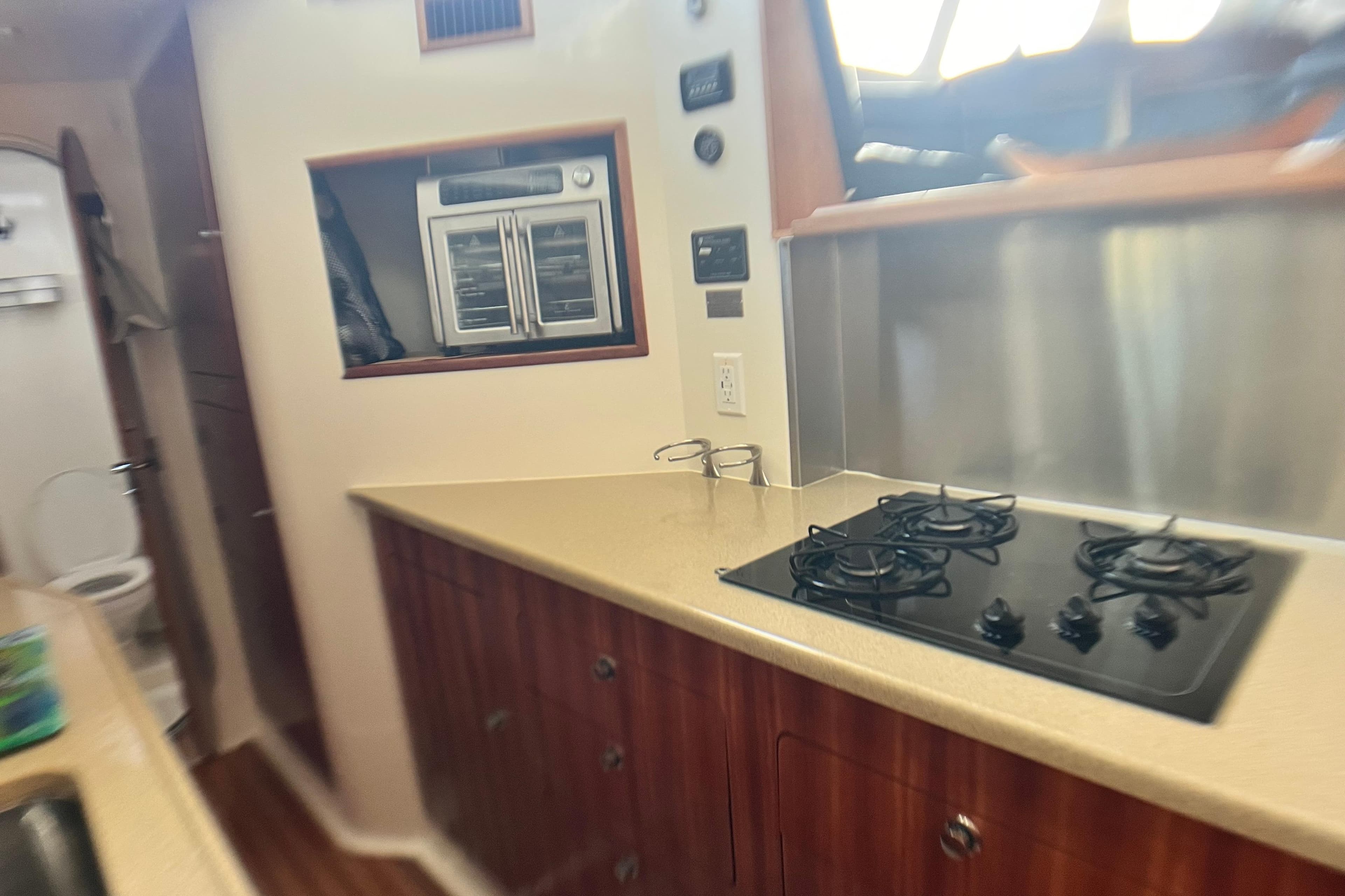 Compact kitchen in 2007 PDQ MV41 boat with stove and oven.