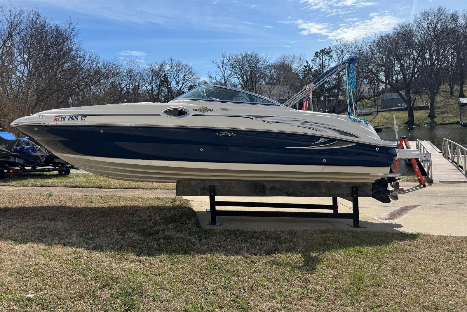 2006 Sea Ray 240 Sundeck boat on display near a dock, clear sky background.