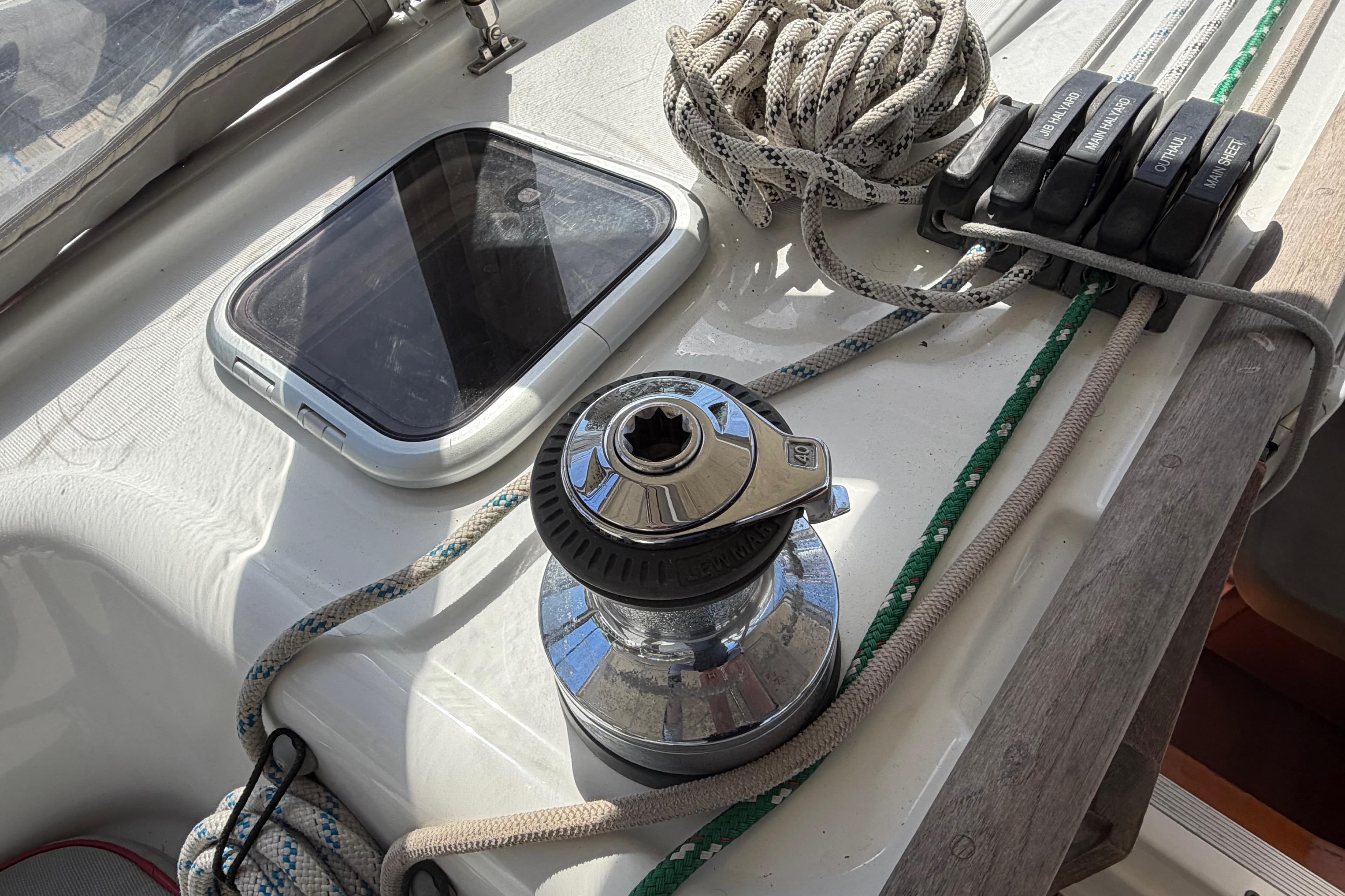 Deck of 2008 Beneteau 43 sailboat with winch, ropes, and hatch.
