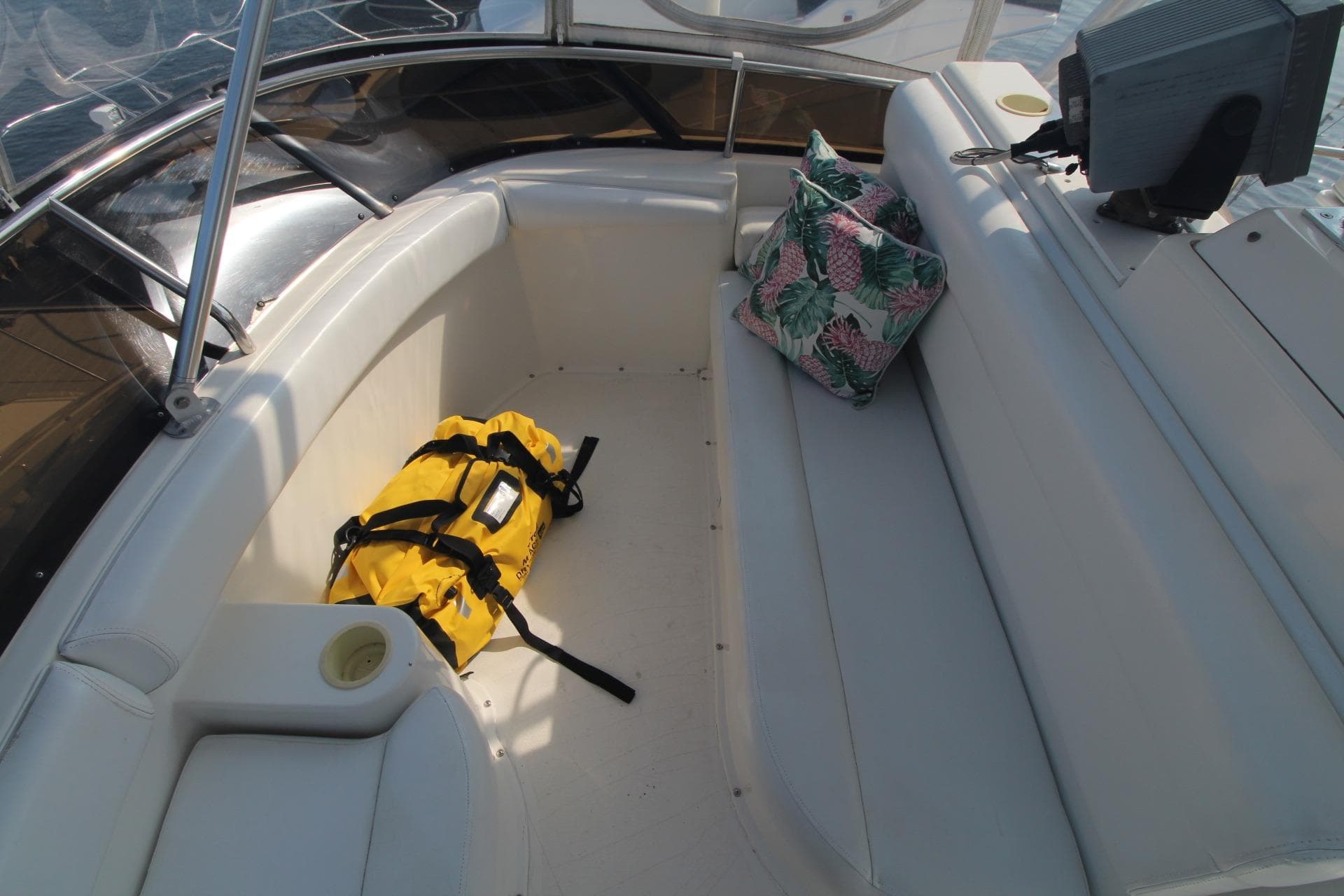 1996 Silverton 41 Convertible boat interior with seating, yellow bag, and floral pillow.