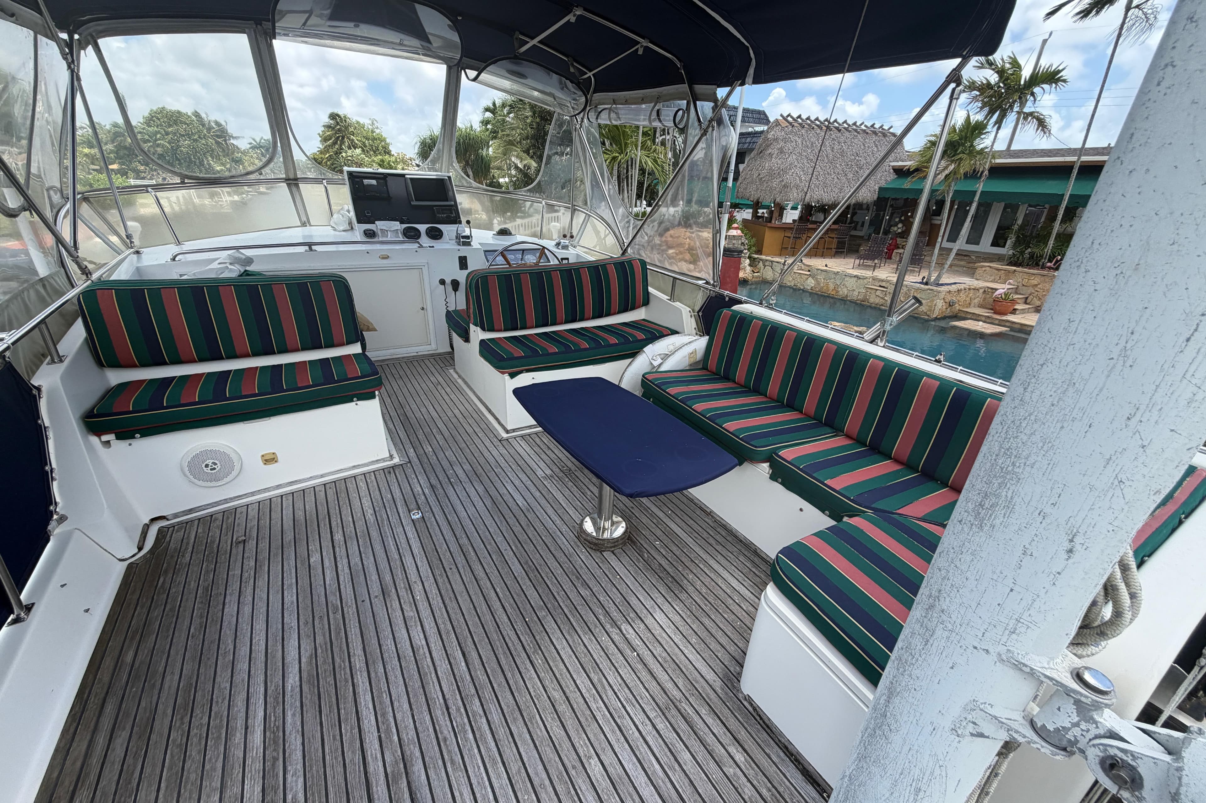 Spacious deck of 1991 Grand Banks 46 Classic yacht with striped seating and wooden flooring.