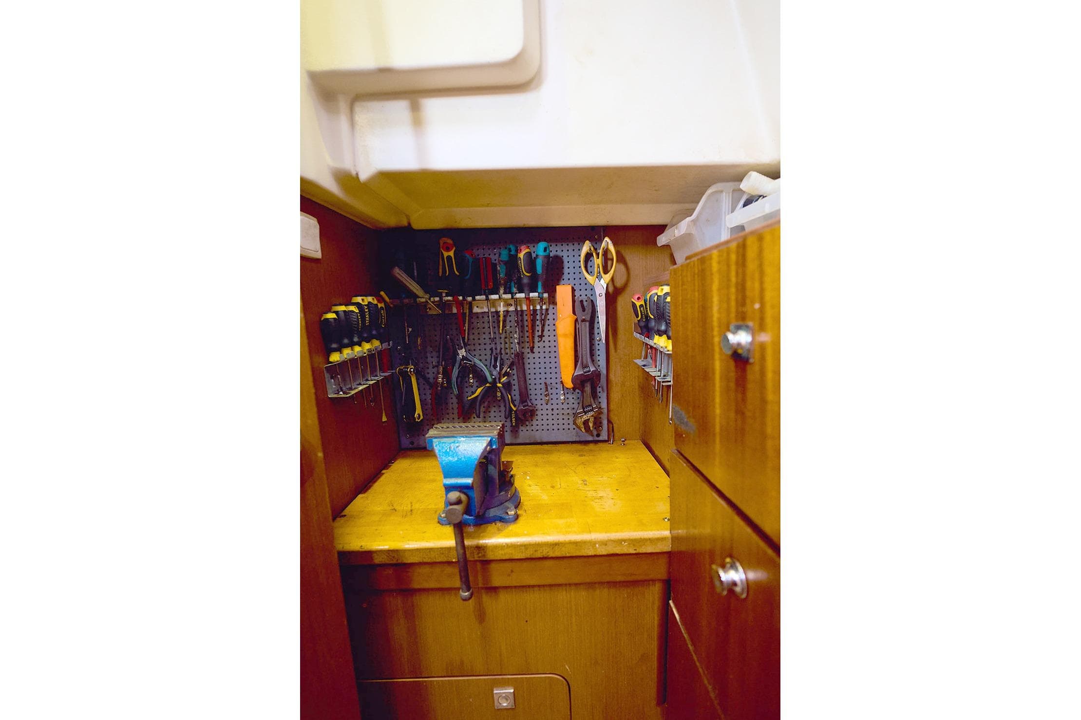 Workshop area on a 2014 Beneteau Oceanis 48 yacht with organized tools and a vise.