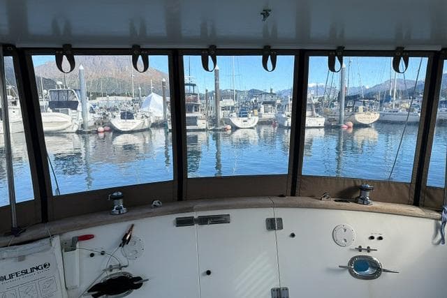 Pilothouse view from a 2001 Nordhavn 46 yacht, overlooking a marina with docked boats.