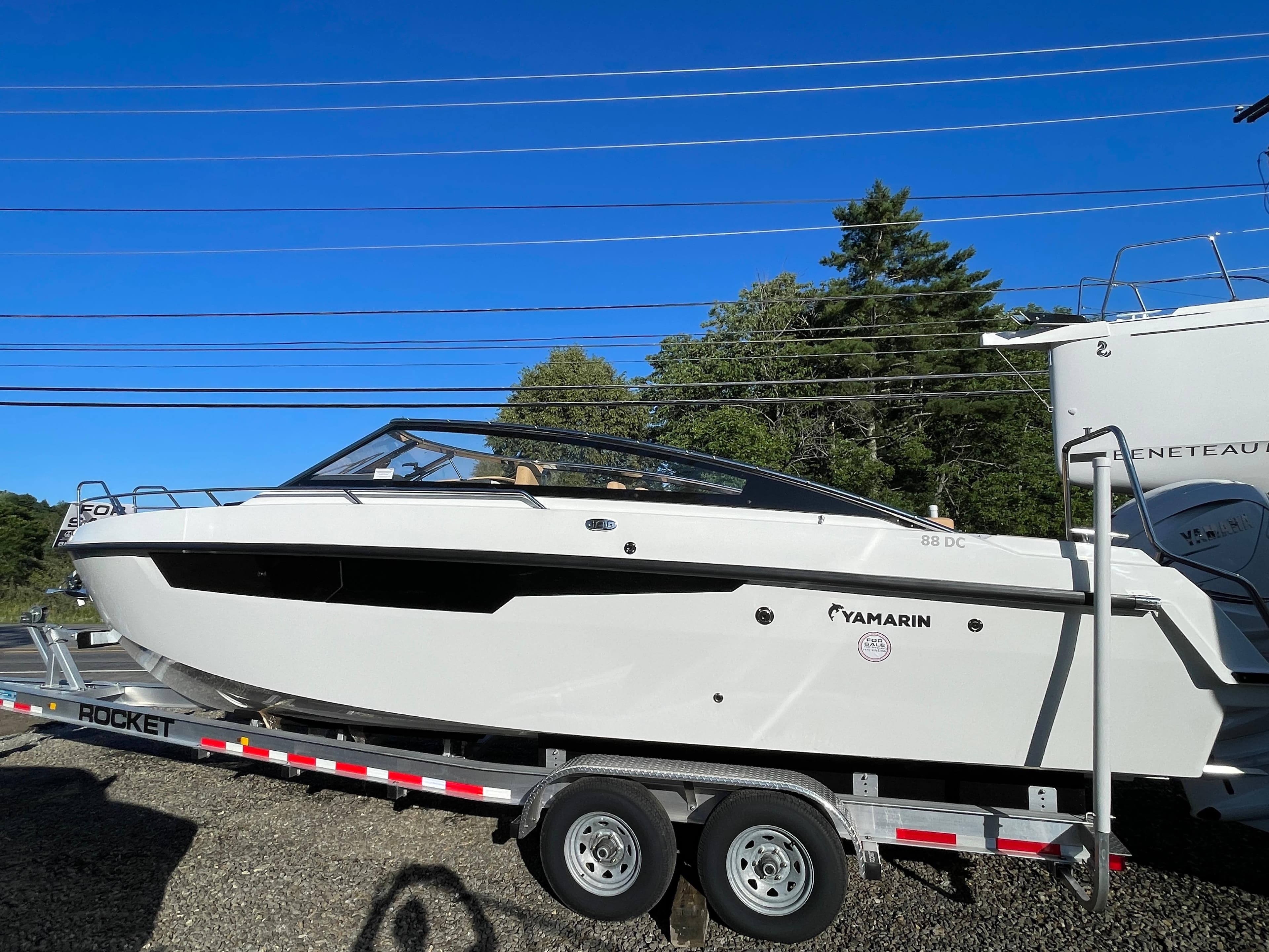 2023 Yamarin 88 DC boat on trailer under clear blue sky.