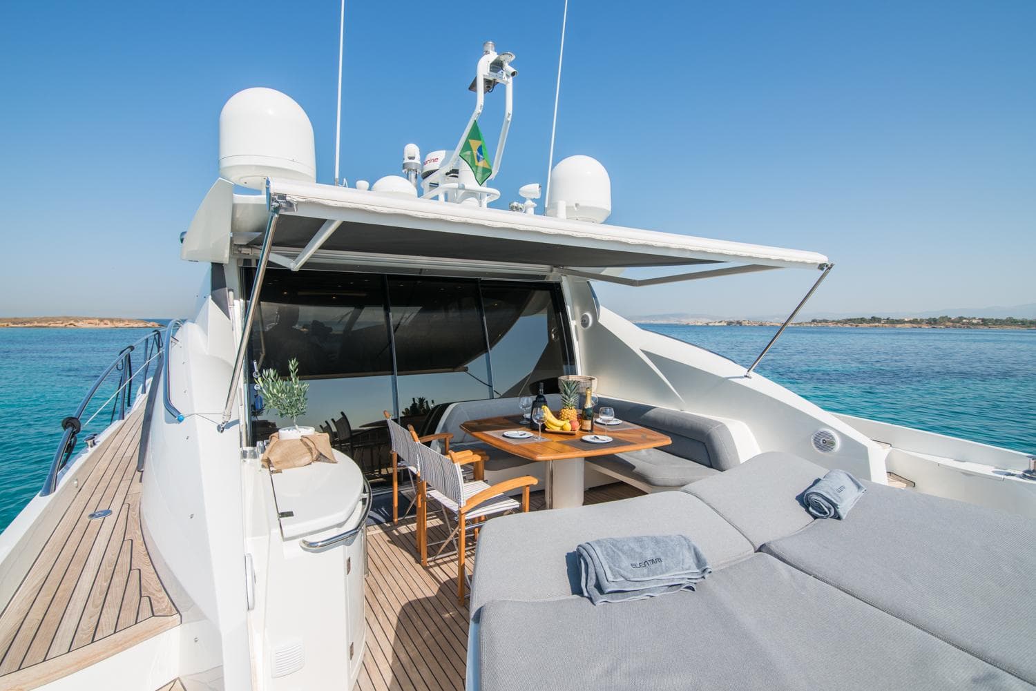 Luxurious 2009 Sunseeker Predator 72 yacht with outdoor dining and sunbathing area.