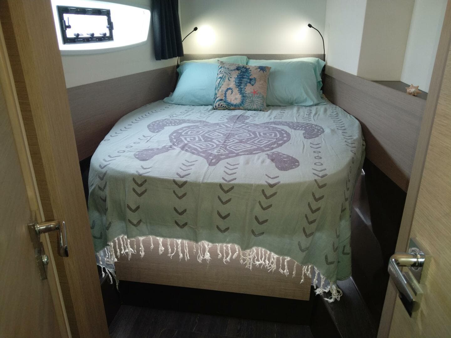 Cozy bedroom in 2020 Fountaine Pajot Astrea 42 catamaran with decorative bedding and soft lighting.