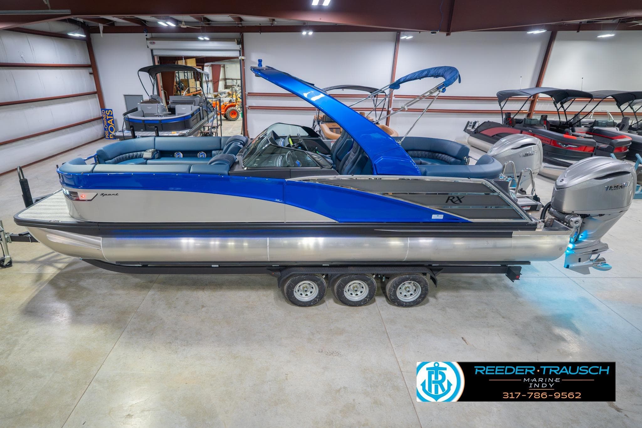 2026 Bennington 27 RX pontoon boat in showroom, featuring sleek design and dual outboard motors.