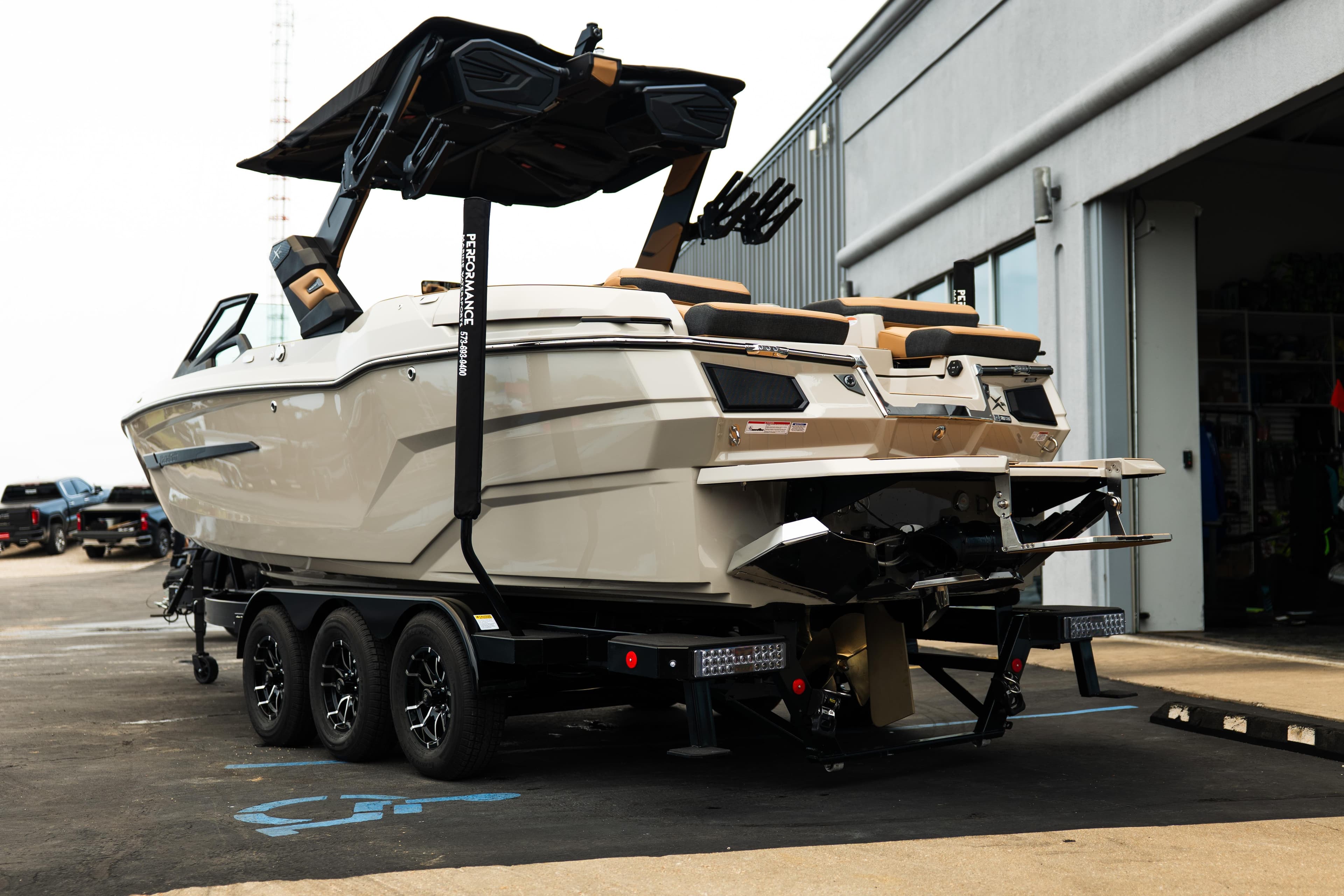 2026 MasterCraft X24 boat on trailer, parked outside a building.