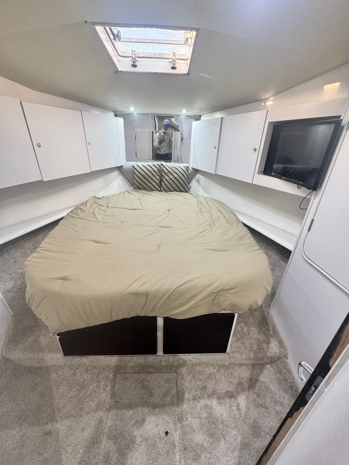Interior of 2000 Ocean Yachts 48 with bed, TV, and storage cabinets.