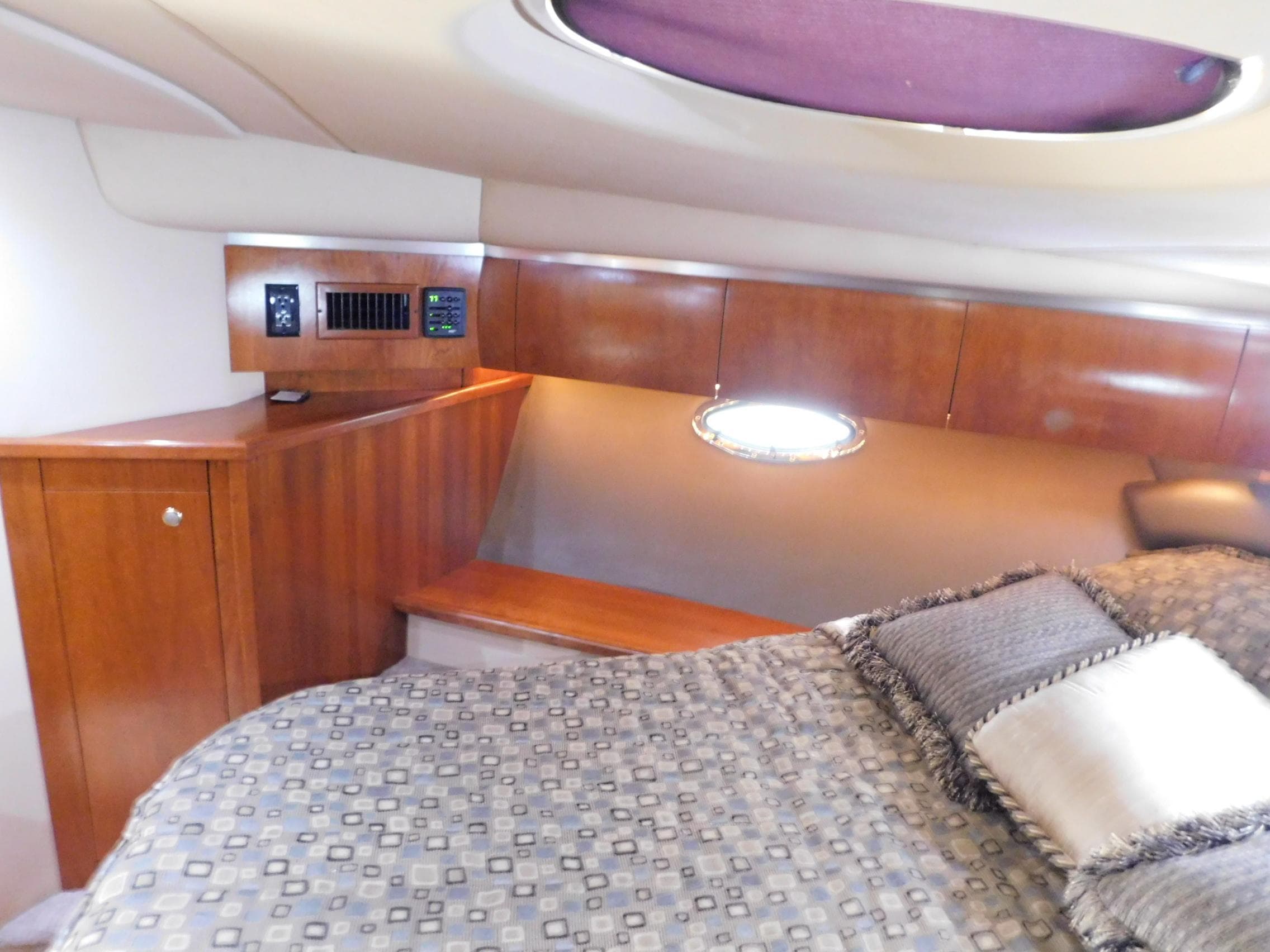 Luxurious cabin interior of 2005 Cruisers Yachts 500 Express with wood paneling and bedding.