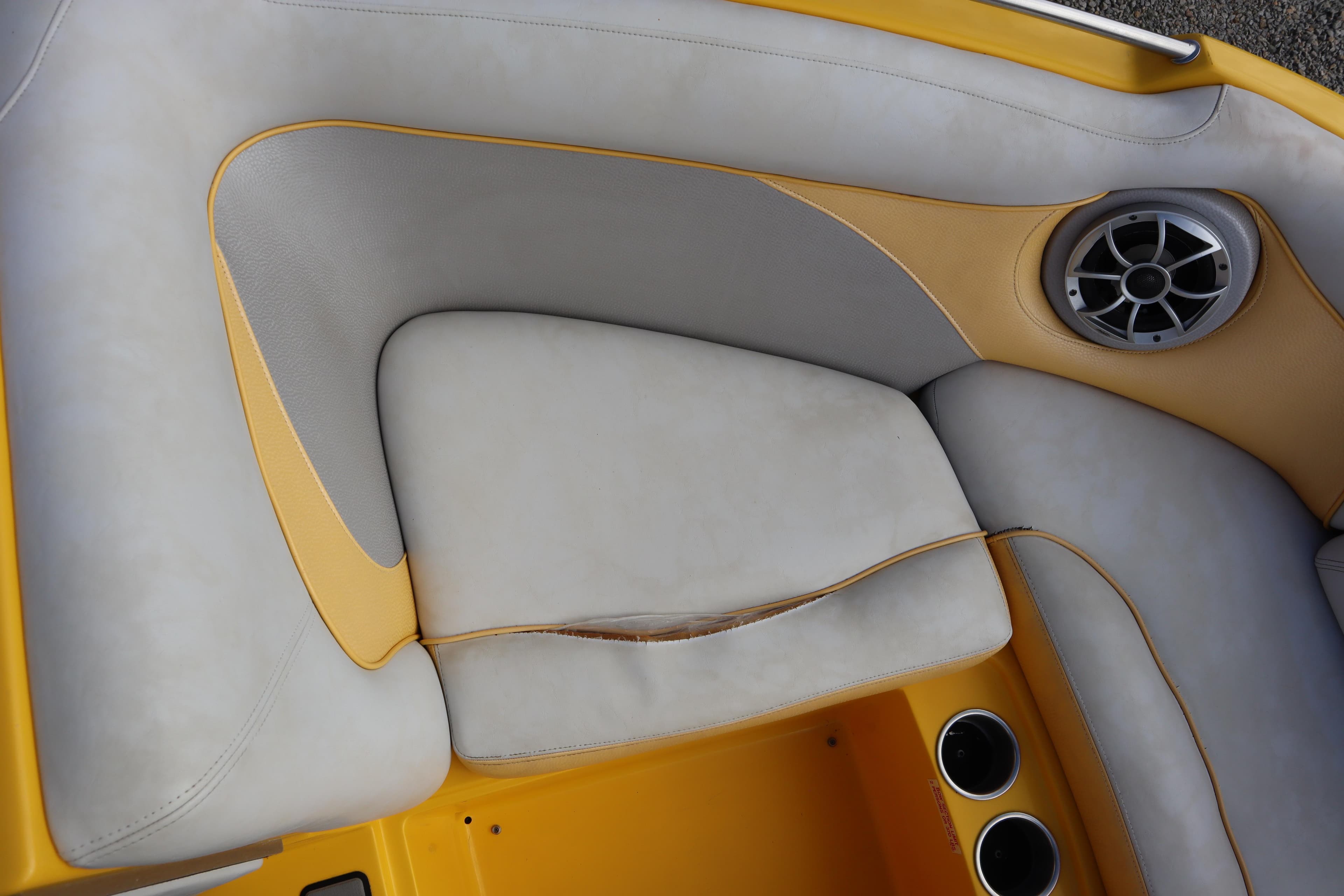 2014 Centurion Enzo SS210 boat interior with yellow and gray seating, speaker, and cup holders.