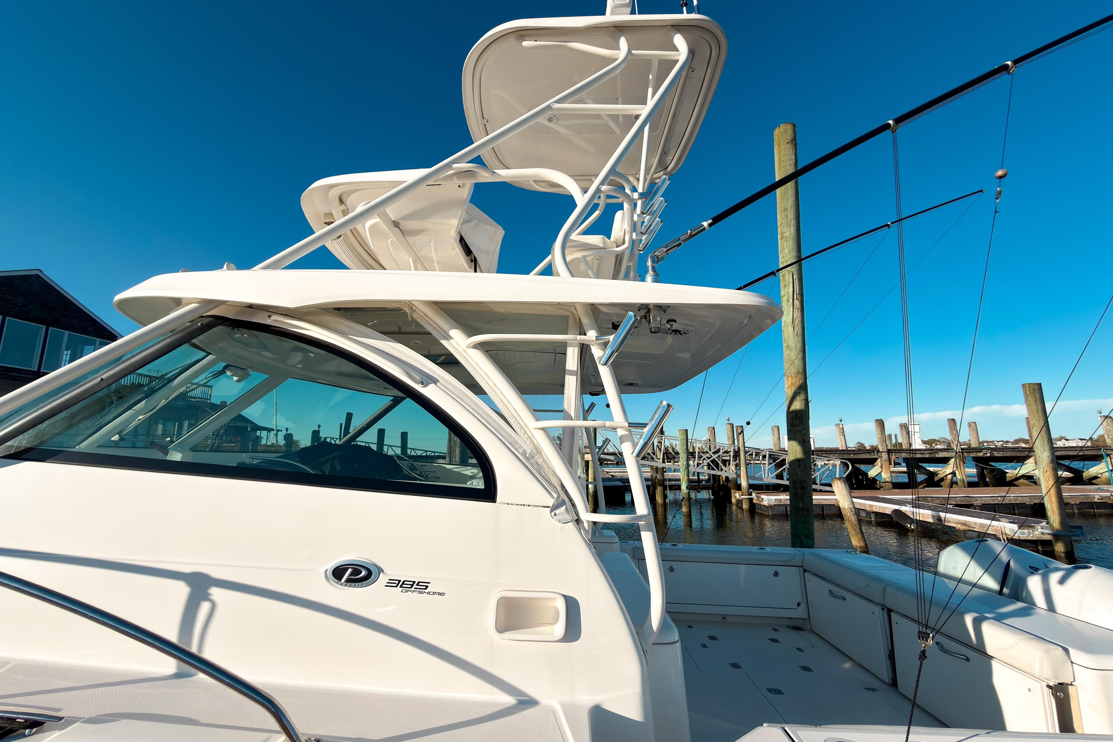 2021 Pursuit OS 385 Offshore boat docked at marina under clear blue sky.