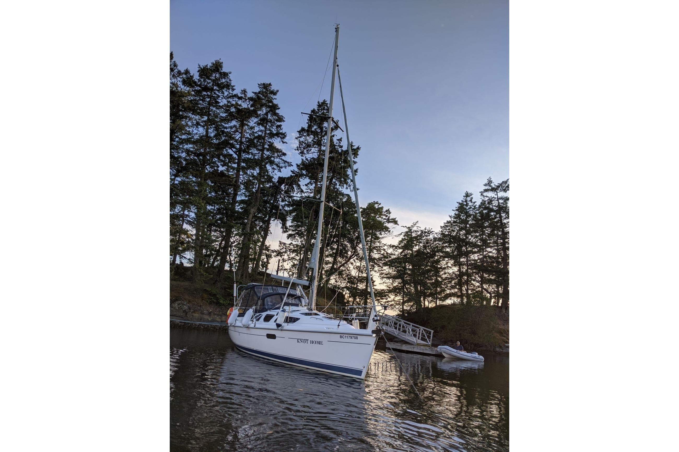 Sailboat Hunter 320 (2001) docked near trees at sunset.