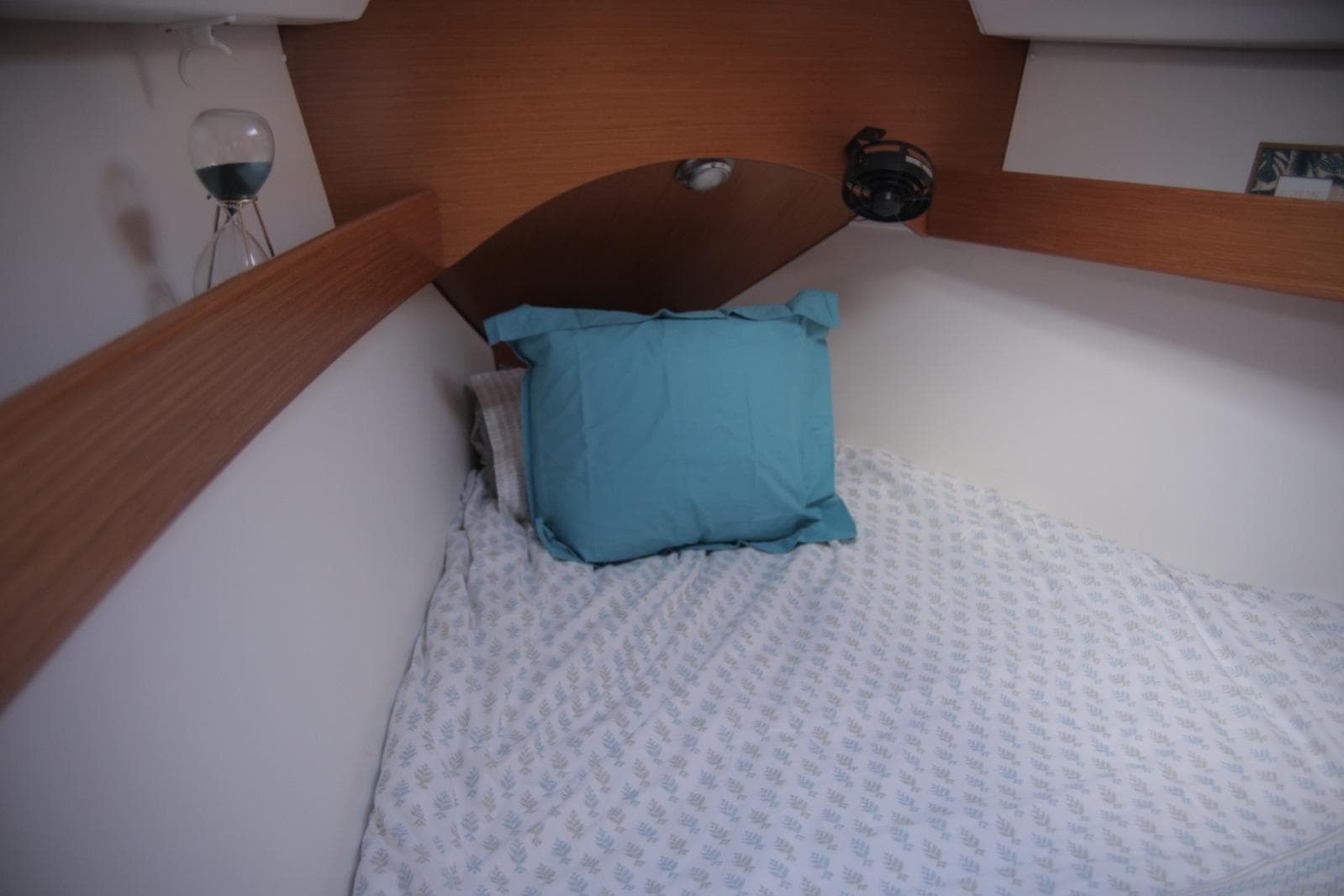Cozy cabin bed in 2007 Beneteau Cyclades 43.3 yacht with blue pillow.