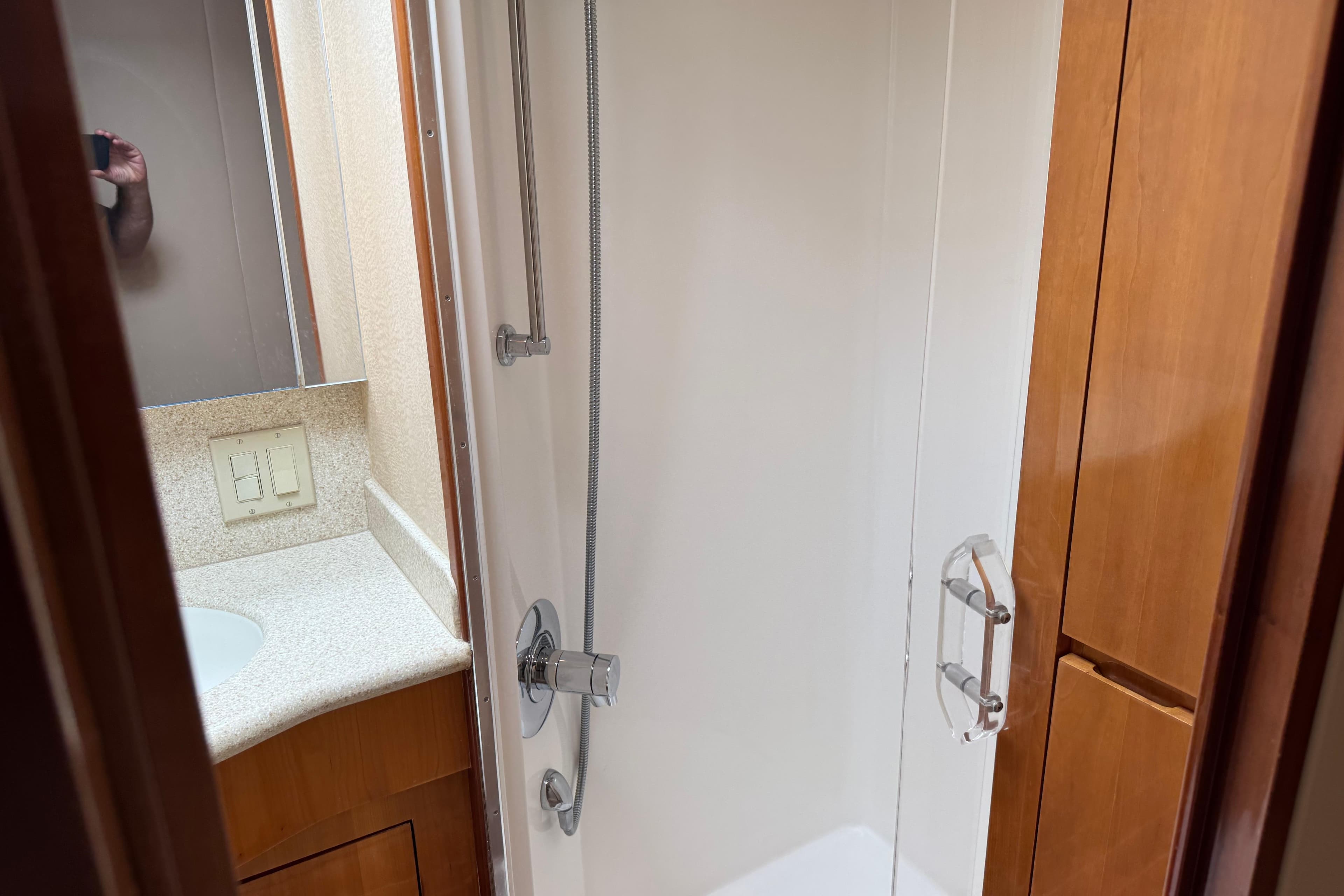 Bathroom interior of 2004 Hatteras 60 Convertible yacht with shower and wooden cabinetry.