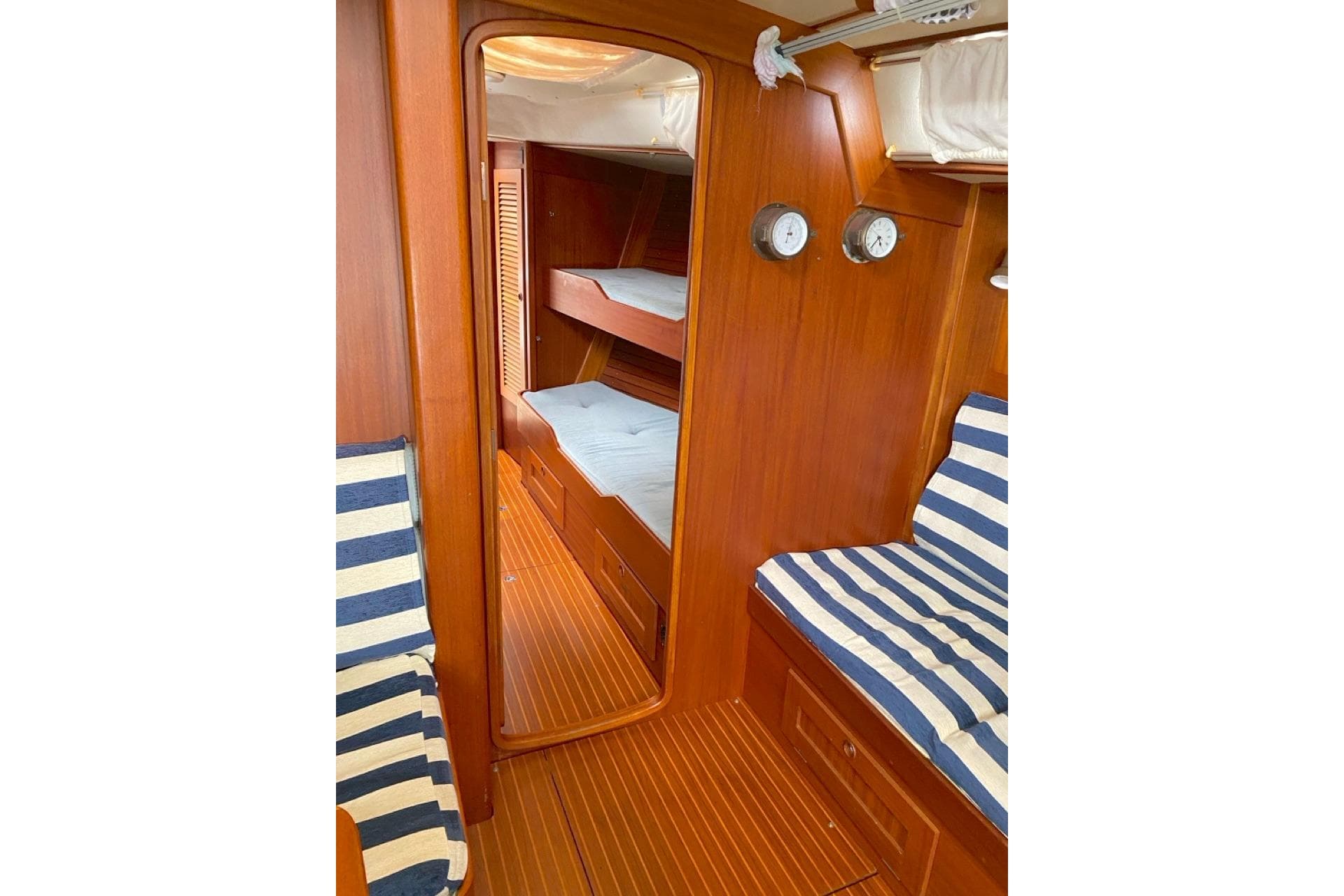 Interior of 1992 Hallberg-Rassy 45 yacht with wooden finish and striped seating.