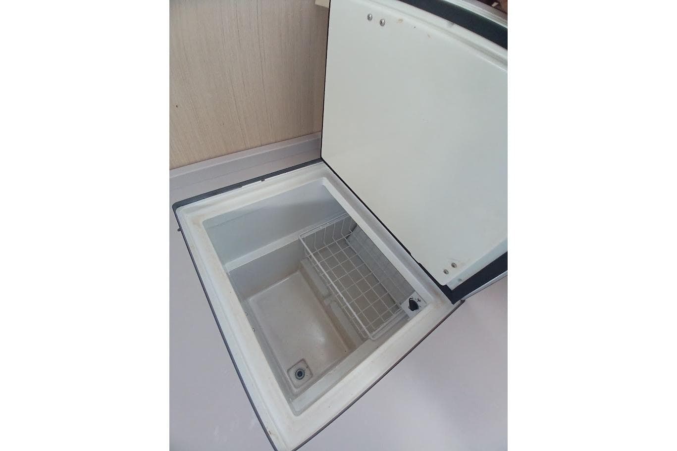 Open storage compartment on 2020 Beneteau Oceanis 46.1 yacht, featuring a wire basket.