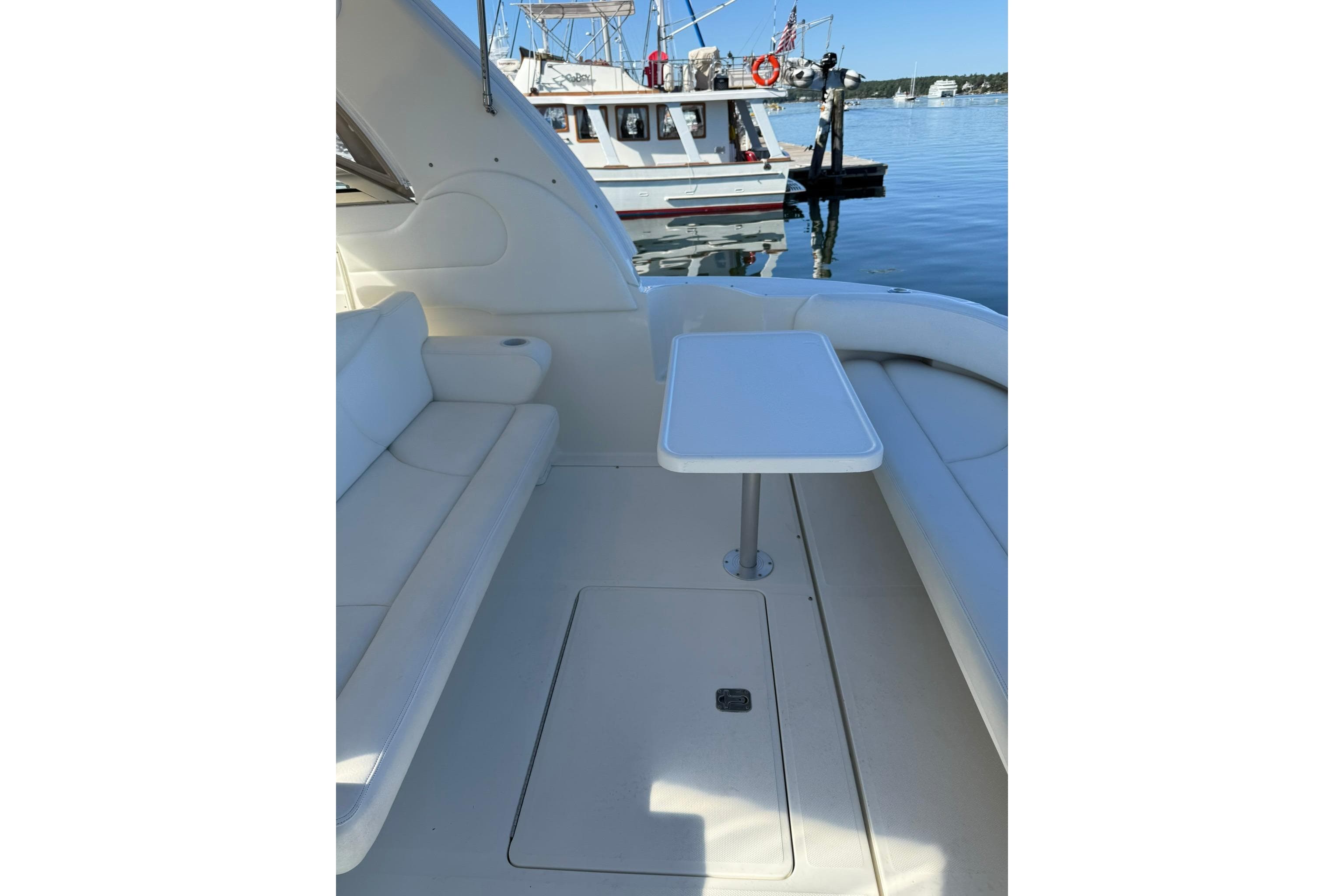 2000 Sea Ray 410 Express Cruiser interior with seating and table, docked by the water.