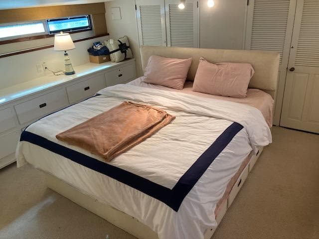 Luxurious bedroom interior of 1977 Bertram 58 Motor Yacht with cozy bedding.