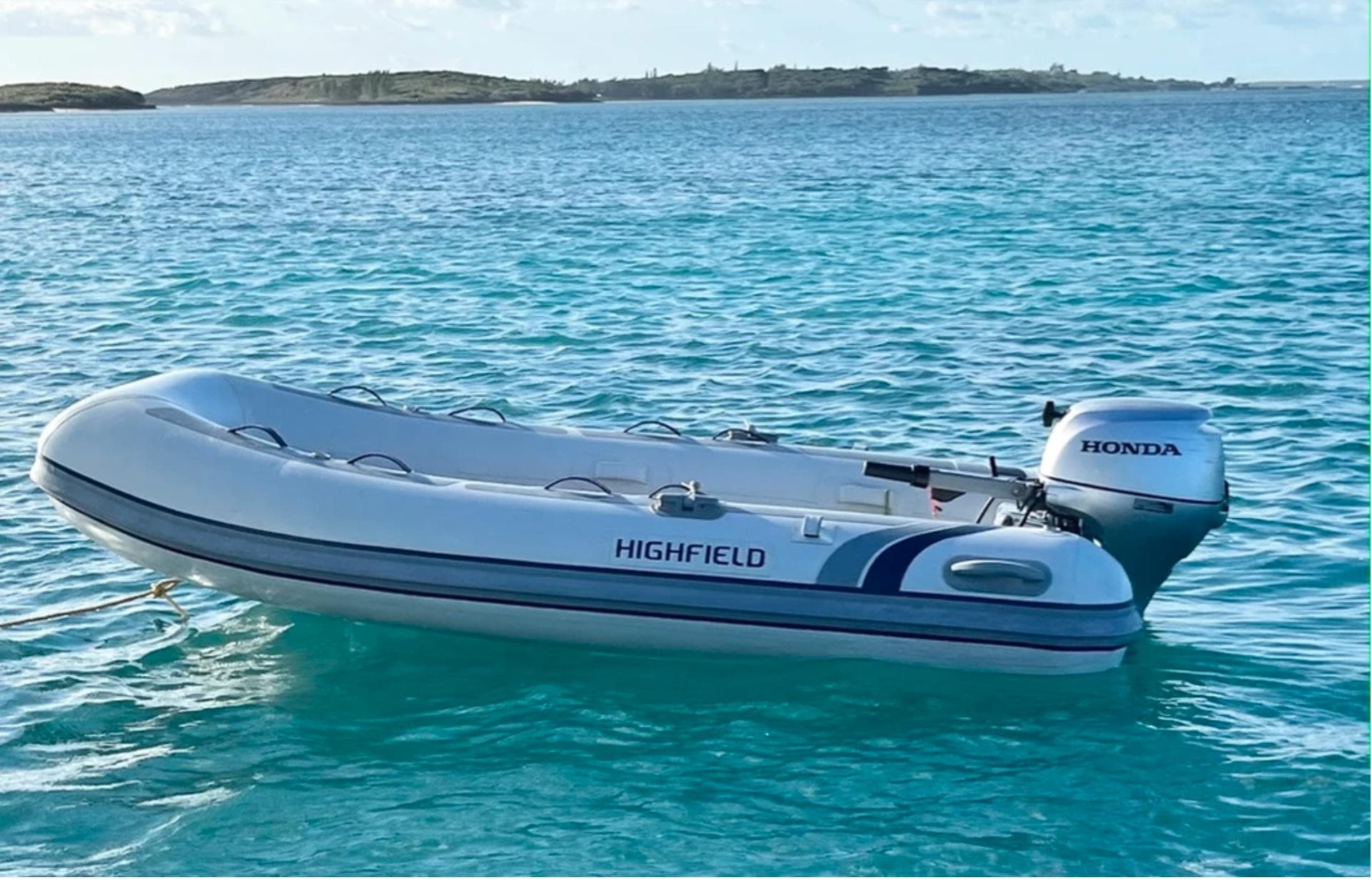 Inflatable boat with Honda motor on turquoise water, Leopard 40, year 2018.