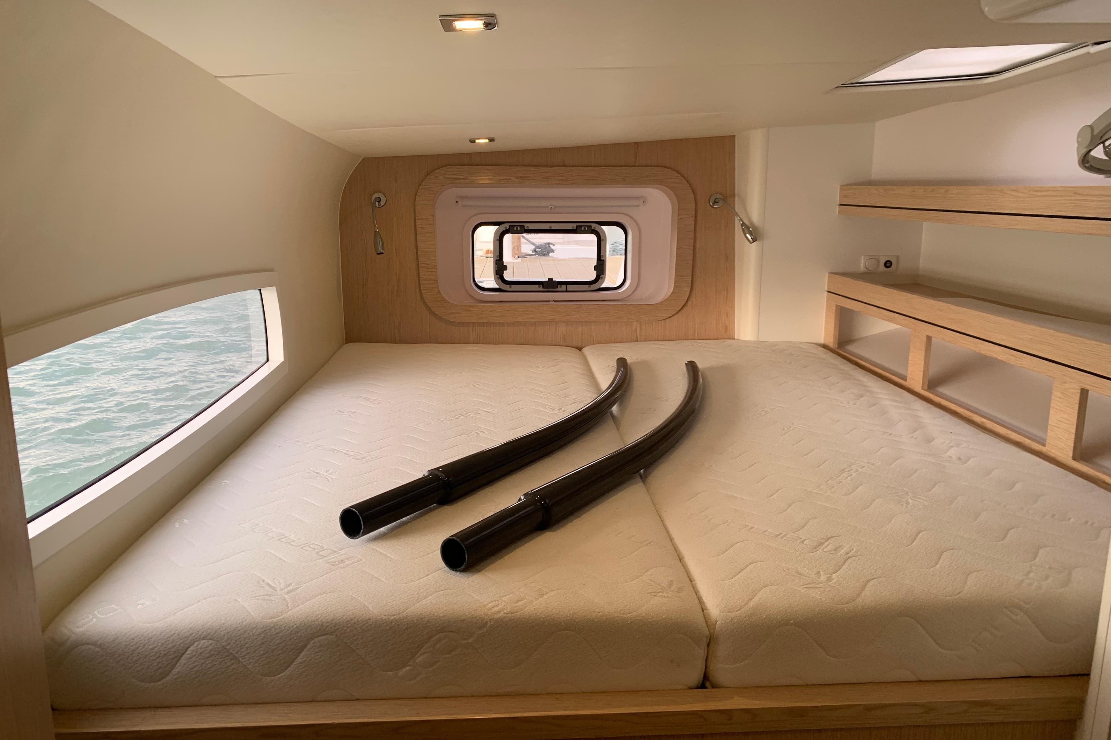 Interior cabin of 2021 Outremer 51 yacht with bed and window view.