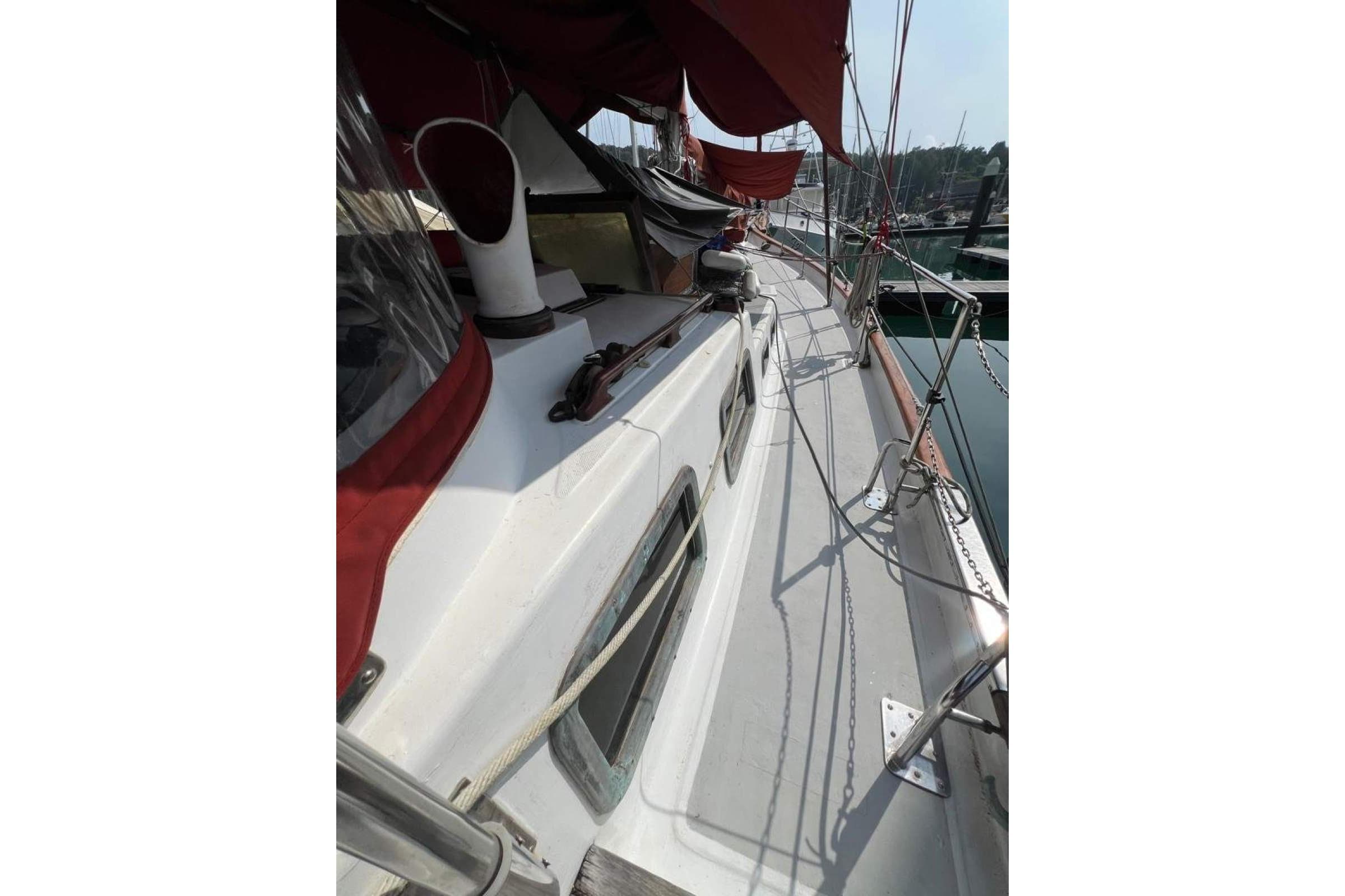 1982 Vagabond 47 sailboat deck with red canopy and marina view.
