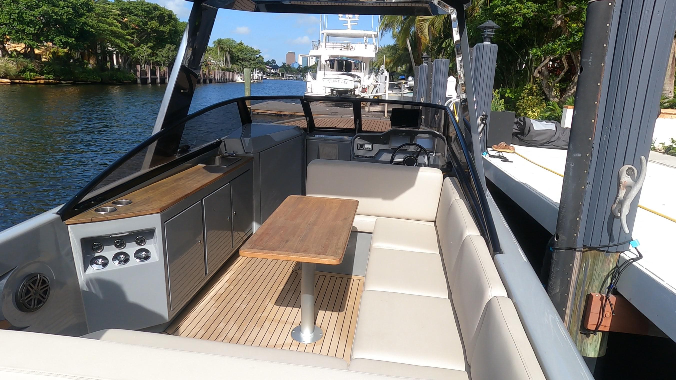 Luxurious 2021 Rand Leisure boat with spacious seating and elegant wooden table on a sunny day.