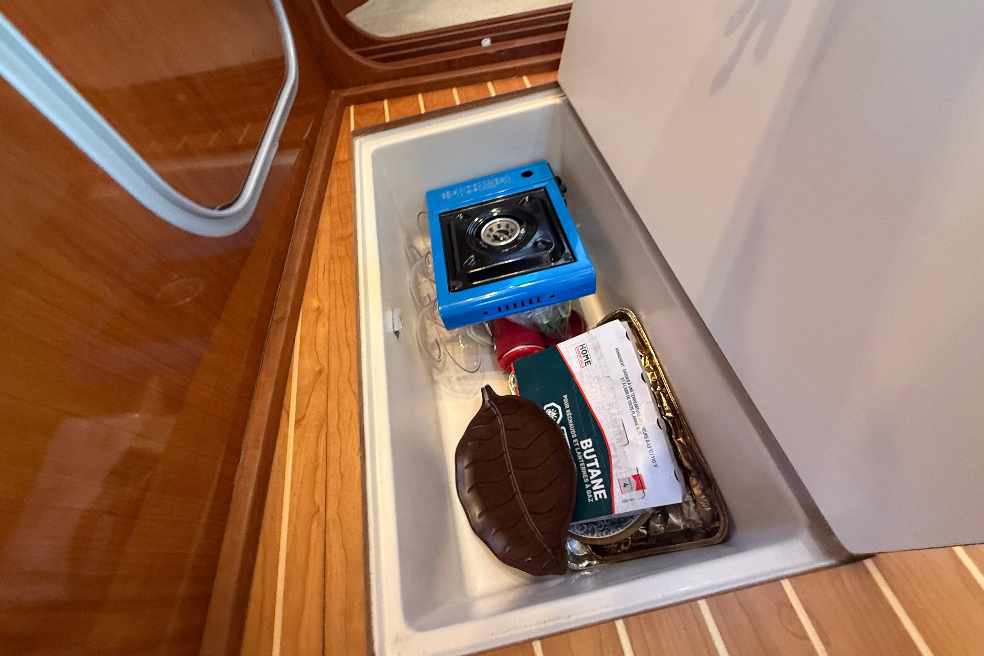Storage compartment in 2006 Regal Commodore 3560 IO with portable stove and butane canister.