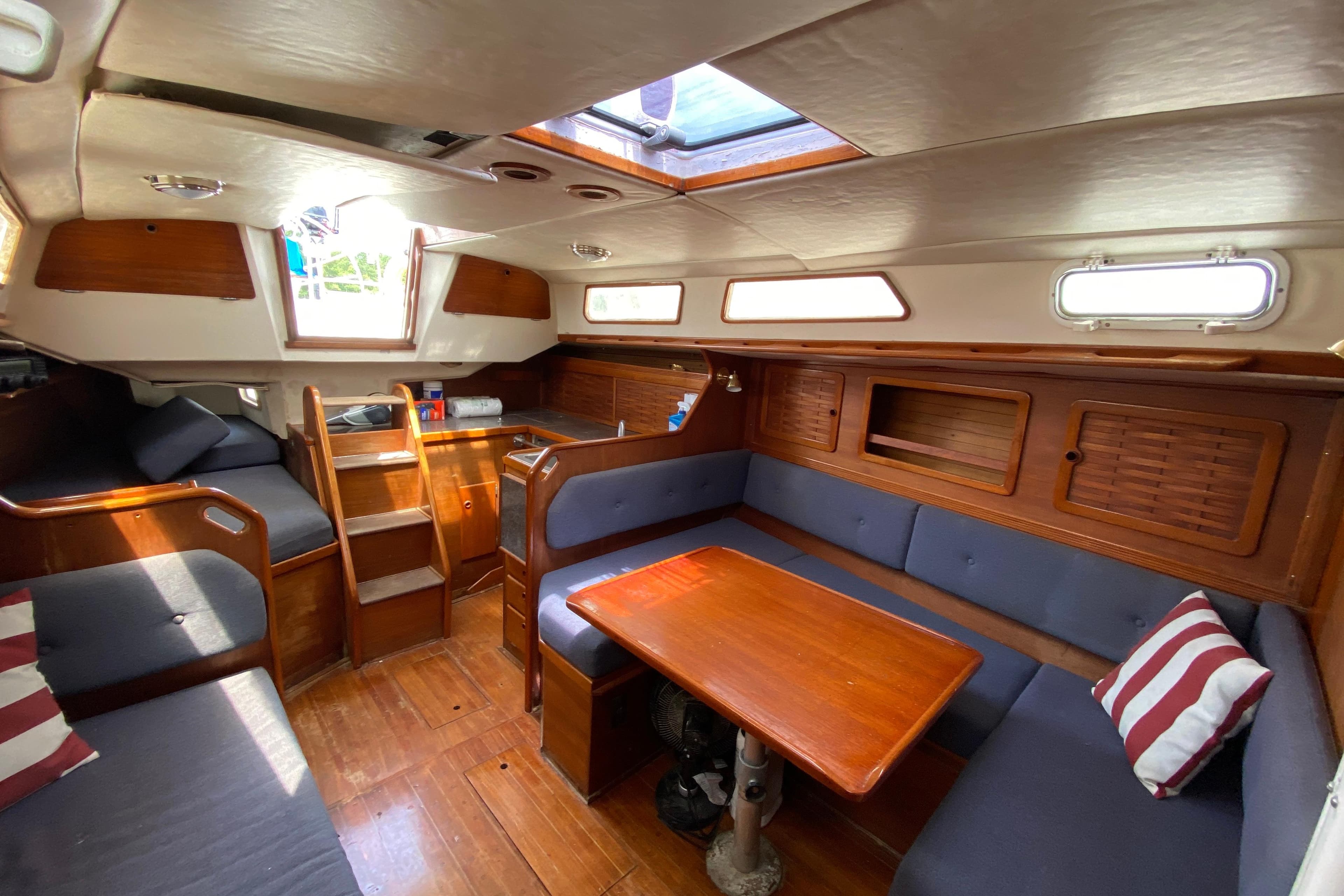 Interior of 1986 Sabre 36 sailboat with wooden furnishings and blue seating.