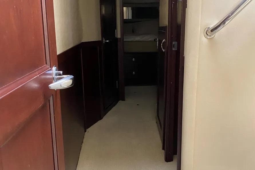 Interior hallway of 2006 Sea Ray 580 Sedan Bridge yacht, featuring wooden doors and beige walls.