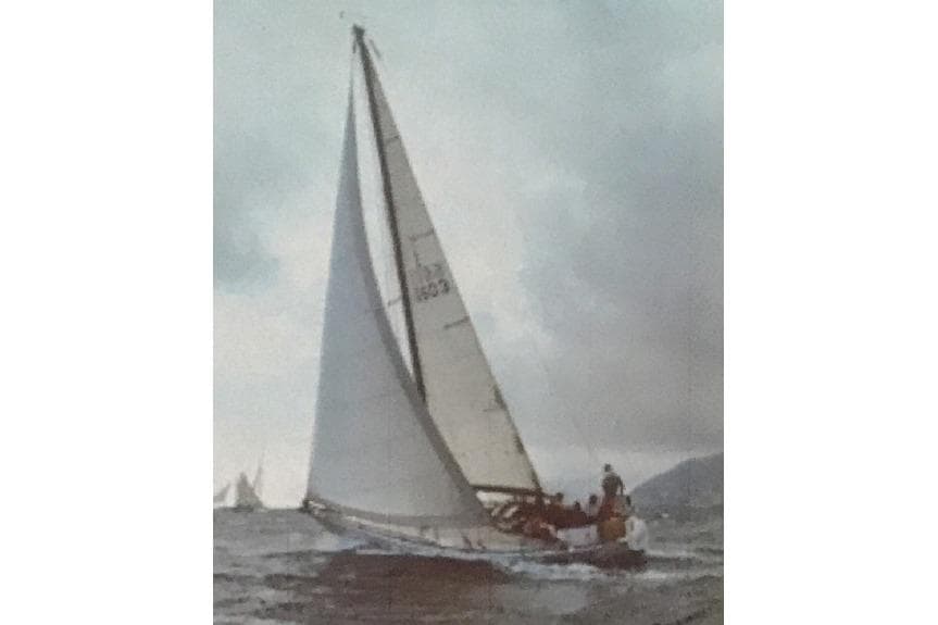 1972 Carlini One Tonner sailboat navigating choppy waters under a cloudy sky.