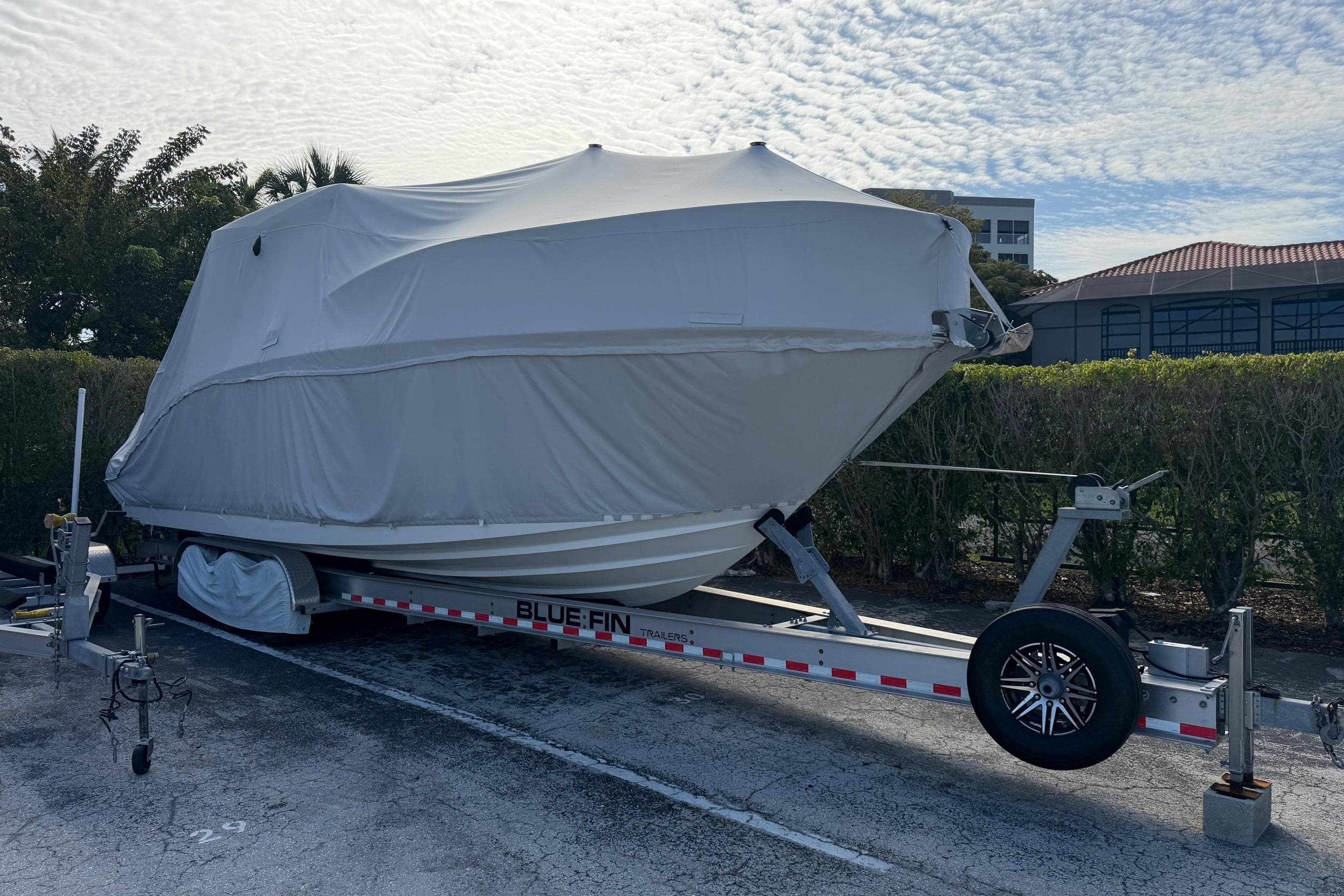 2024 Sea Ray Sundancer 320 Outboard covered on trailer, parked outdoors.