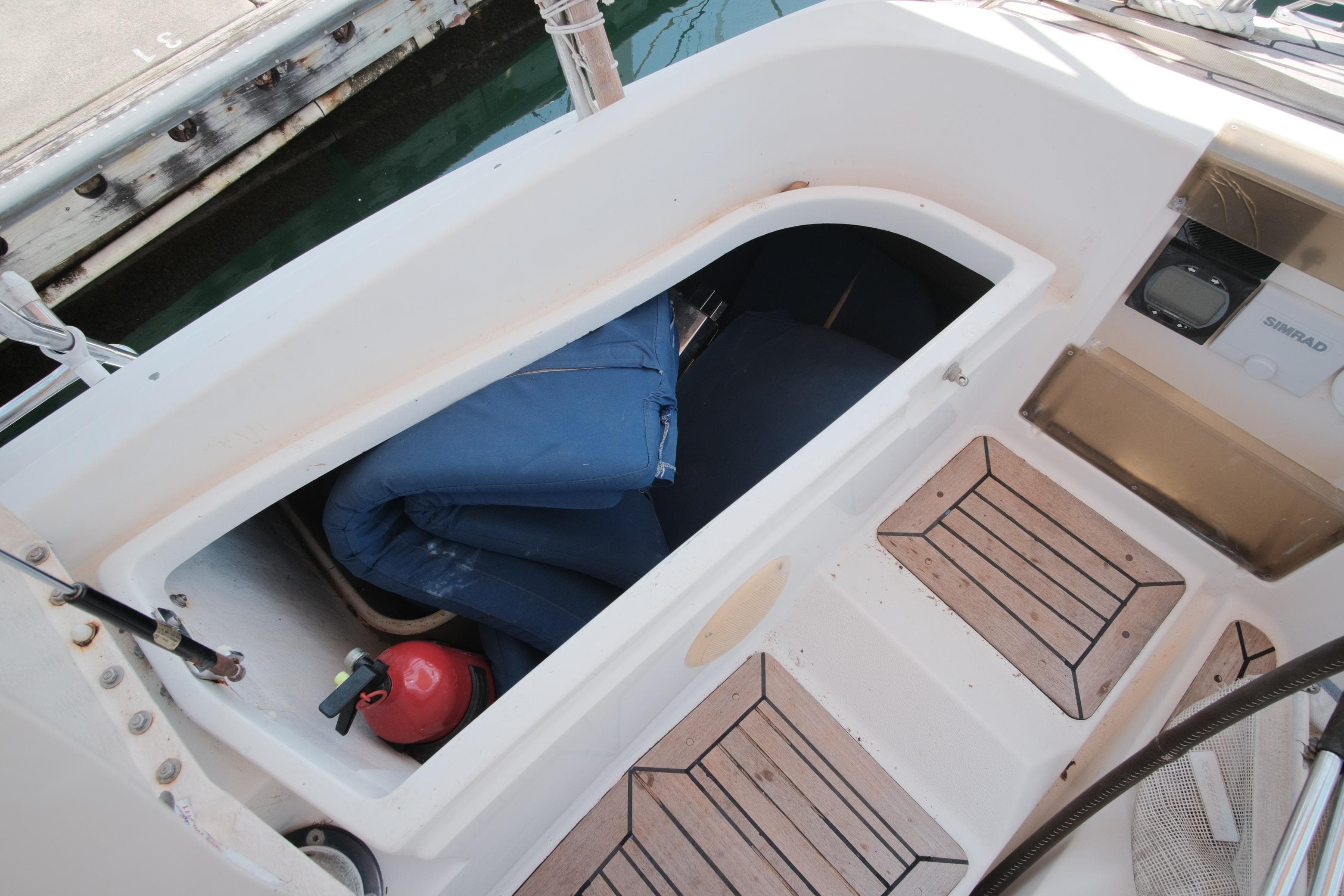 Open storage compartment on 2000 X-Yachts 442 MK II sailboat with equipment and fire extinguisher.