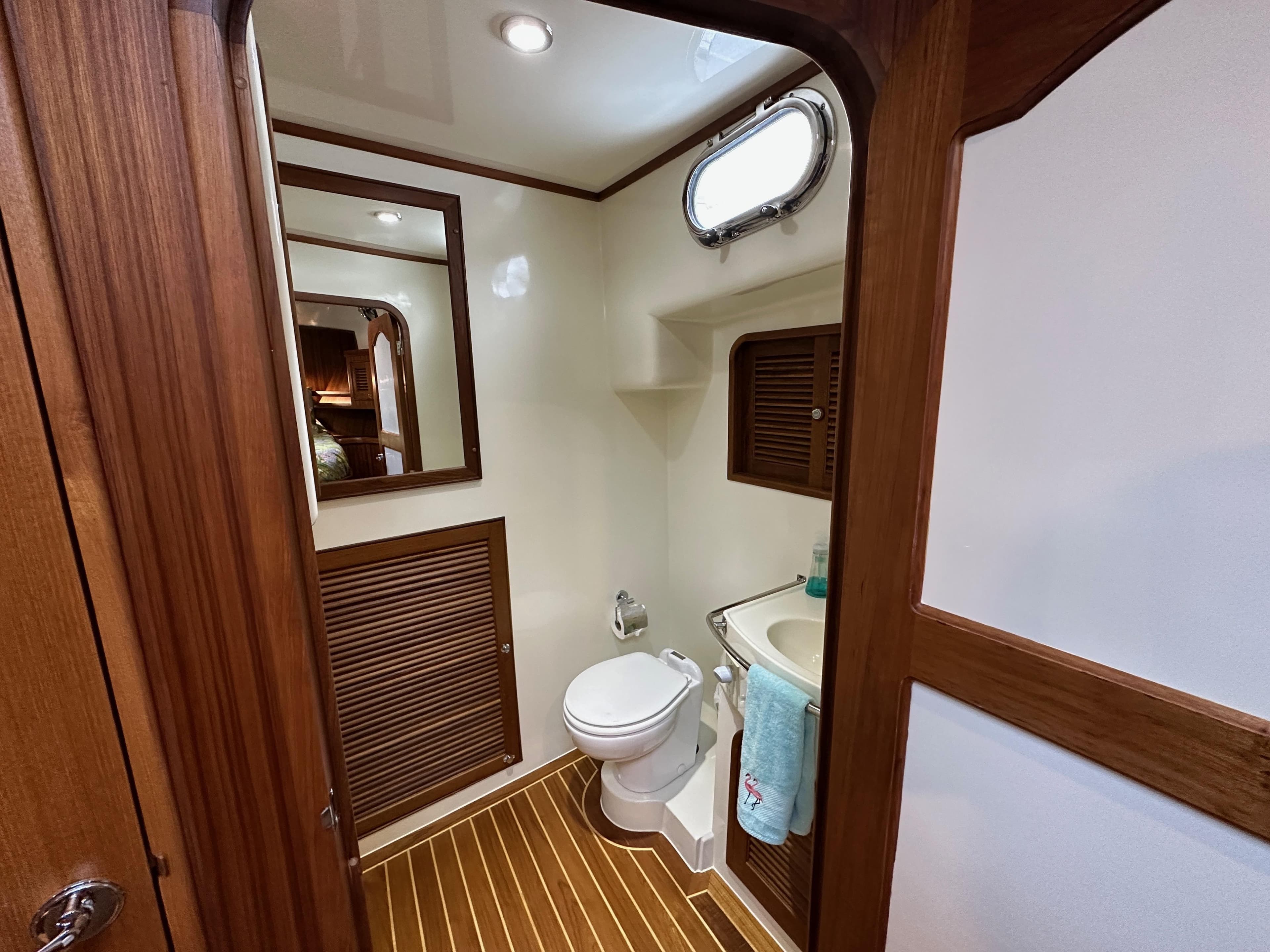 2023 Helmsman Trawlers 43E Pilothouse bathroom with wood accents and compact design.