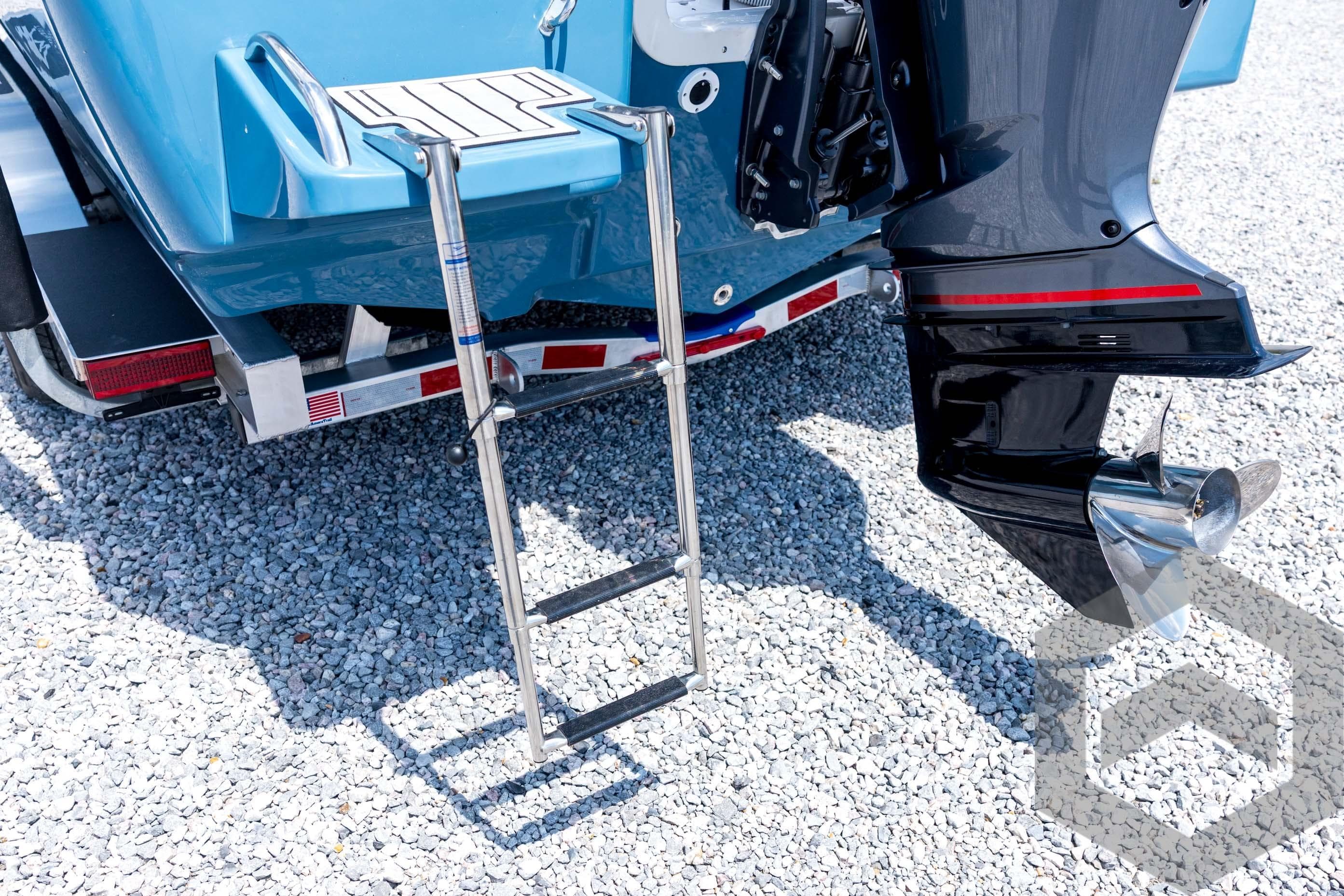 2026 Tidewater 2110 Bay Max boat with ladder and motor on gravel surface.