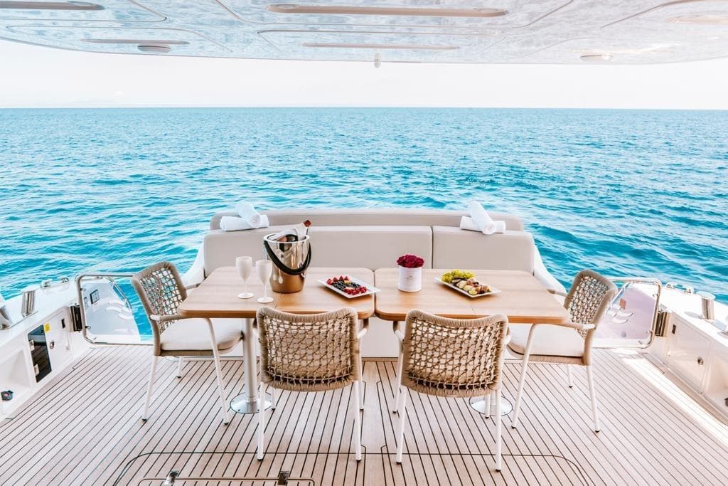 Luxurious Sirena 64 yacht deck with dining setup overlooking the ocean, 2019 model.