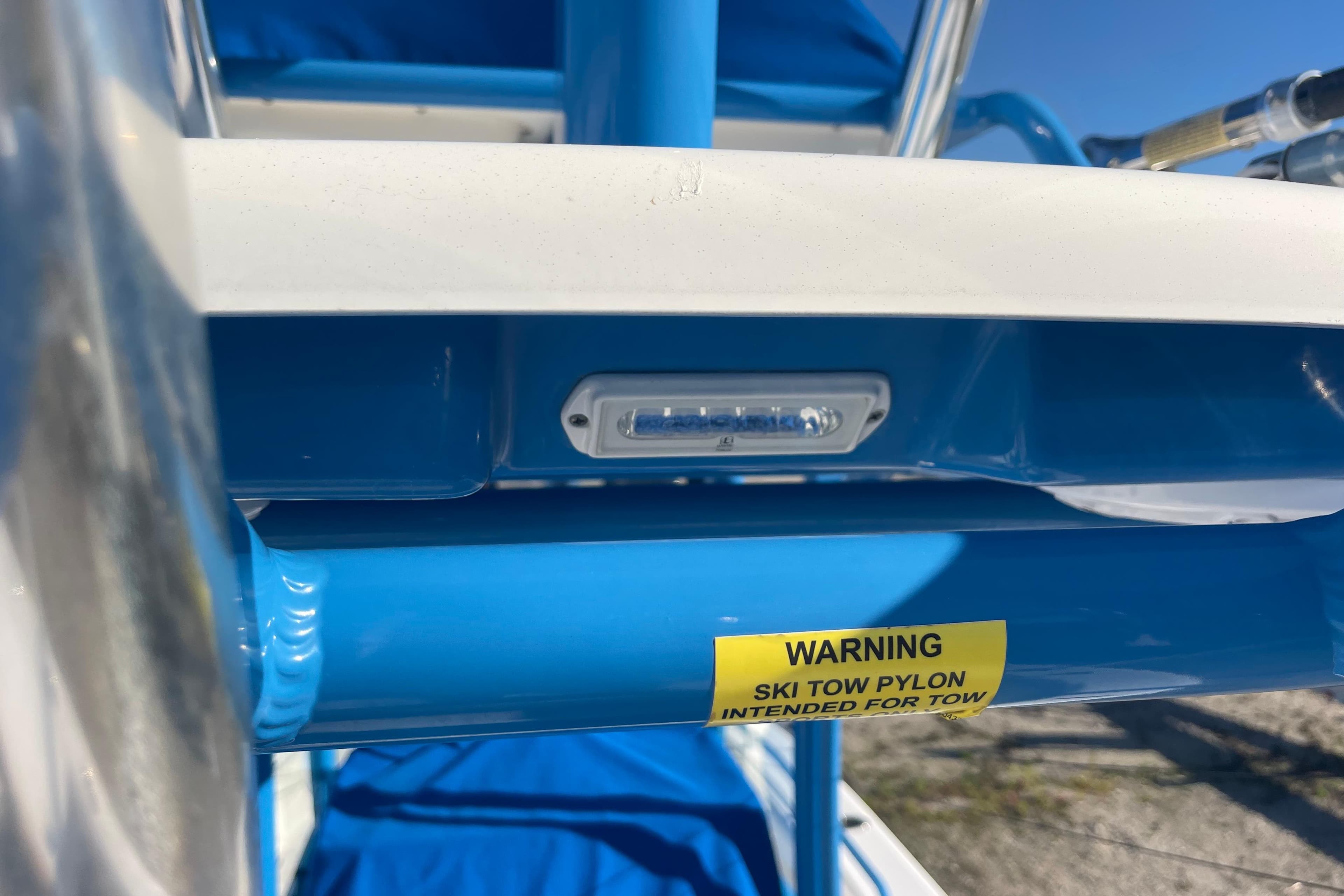 Close-up of 2021 Everglades 243 Center Console boat's ski tow pylon warning label.