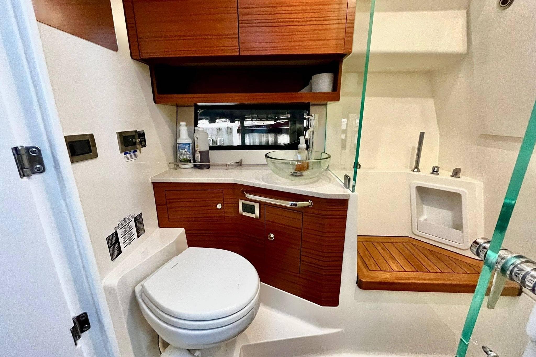 2025 Boston Whaler 365 Pilot House bathroom with modern fixtures and wooden cabinetry.