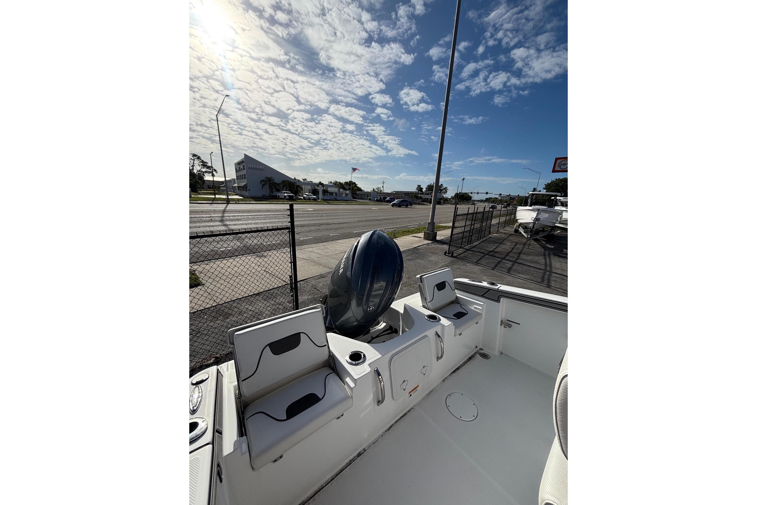 2024 Wellcraft 202 Fisherman boat interior with seating and motor, under a sunny sky.