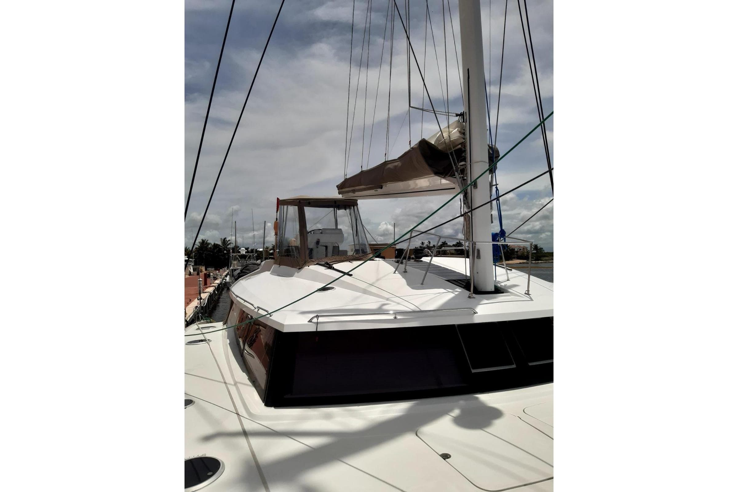 2014 FONTAINE PAJOT 63 yacht deck with mast and rigging under cloudy sky.