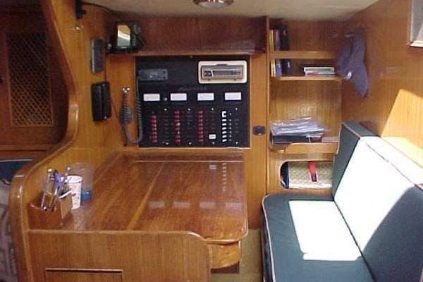 Interior of 1986 Fast Masthead Sloop with wooden table and seating area.