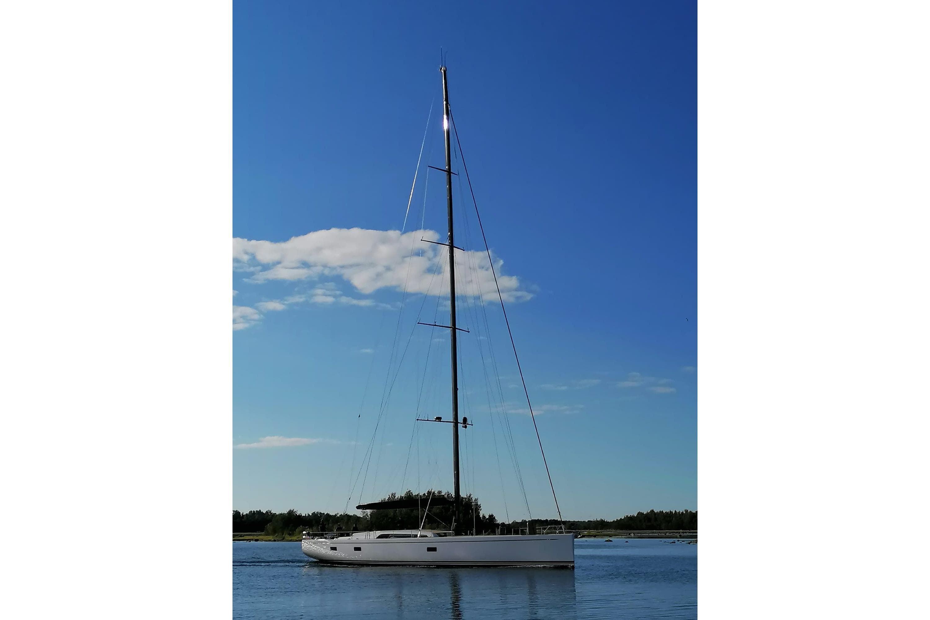 Sailing yacht Nautor Swan 98, 2020 model, on calm water under clear blue sky.