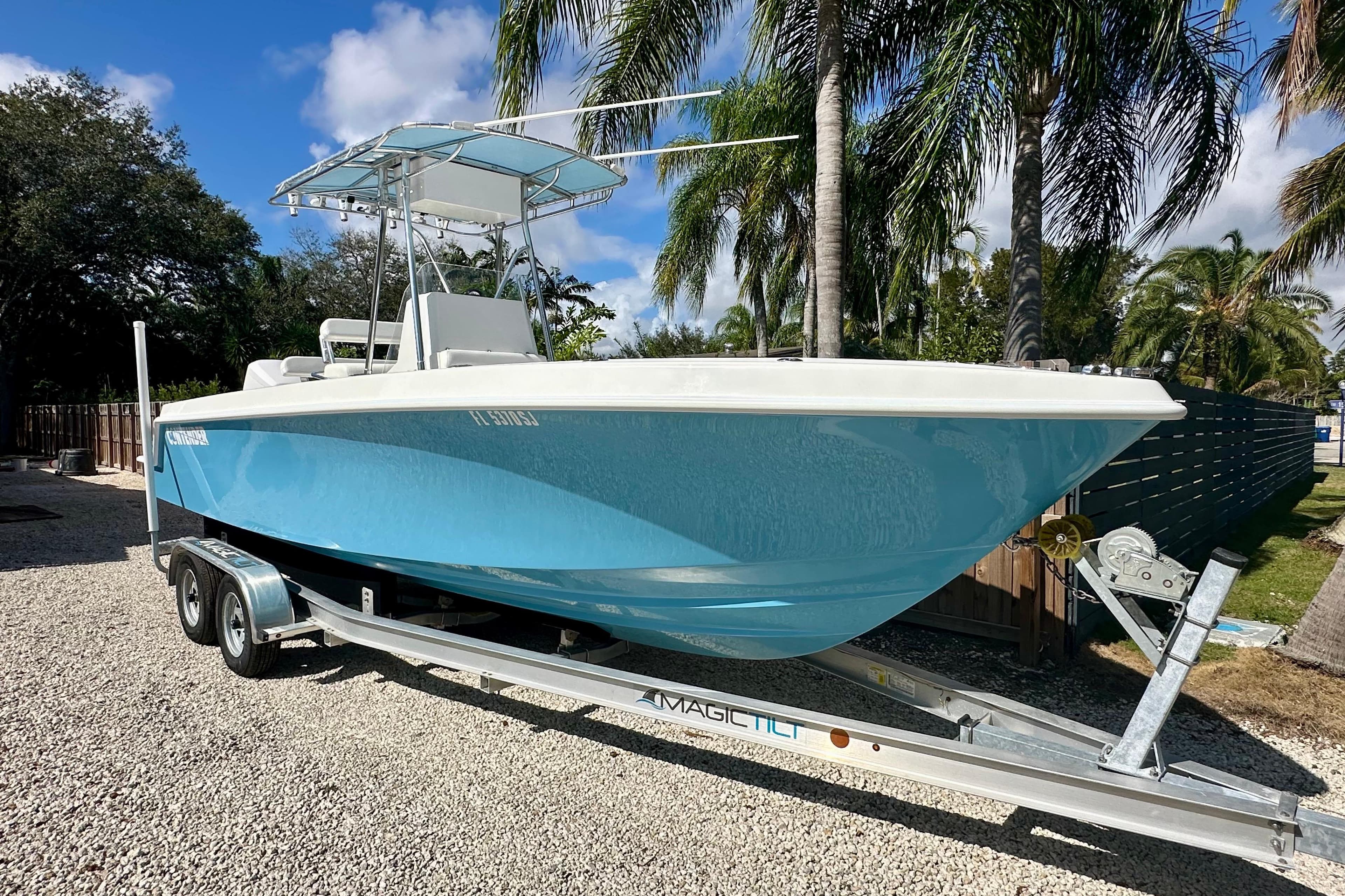 2001 Contender 23 Open boat on trailer, parked outdoors with palm trees.