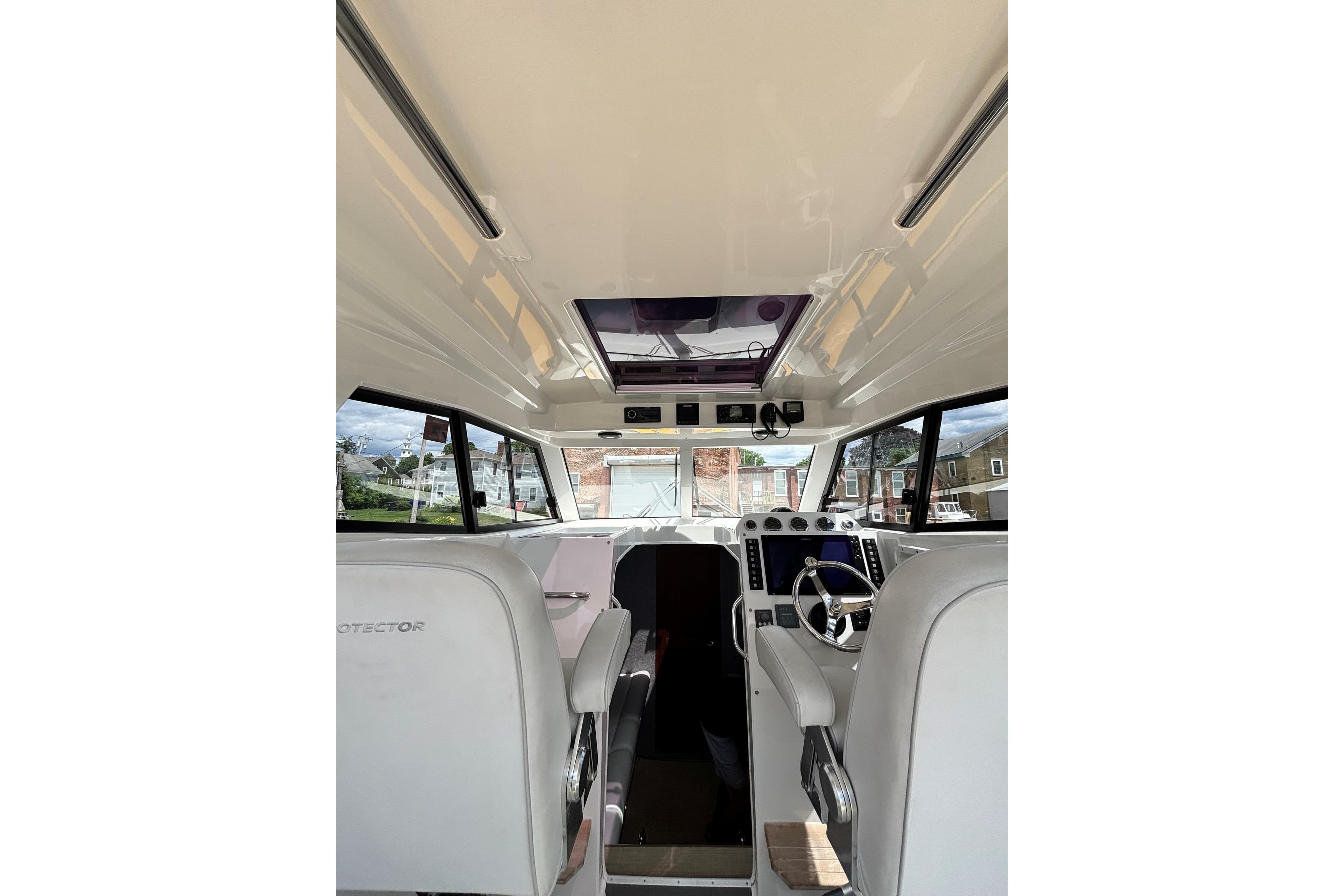 Interior view of 2020 Protector 380 Targa boat, featuring helm and seating area.