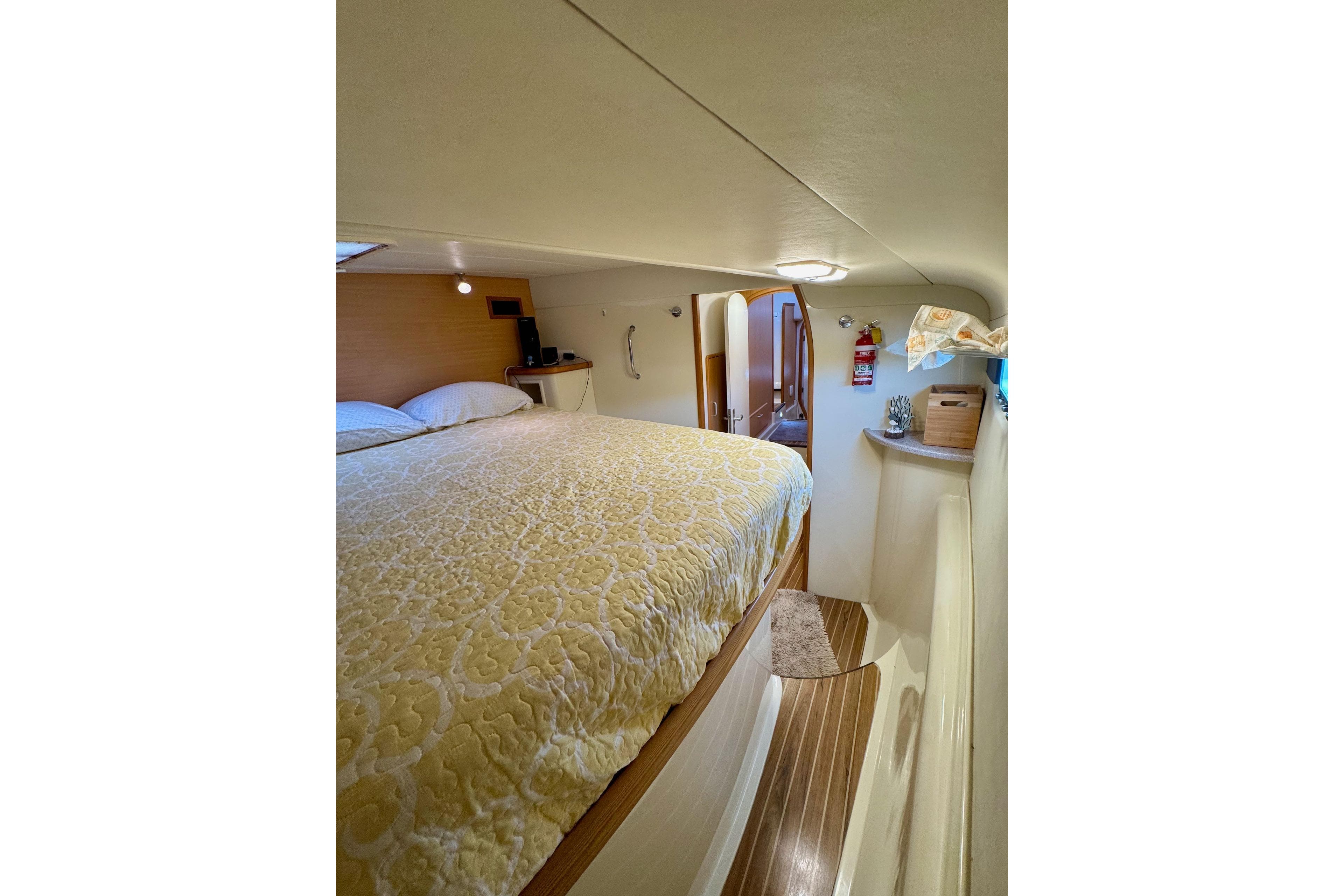 Cozy bedroom interior of a 2004 Leopard 42 yacht with a comfortable bed.