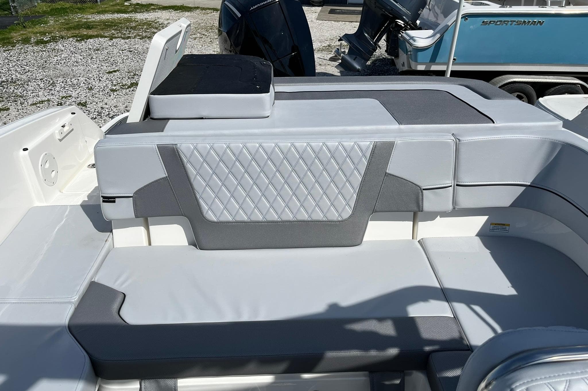 2026 Bayliner VR6 Bowrider OB interior with gray and white seating, diamond pattern upholstery.